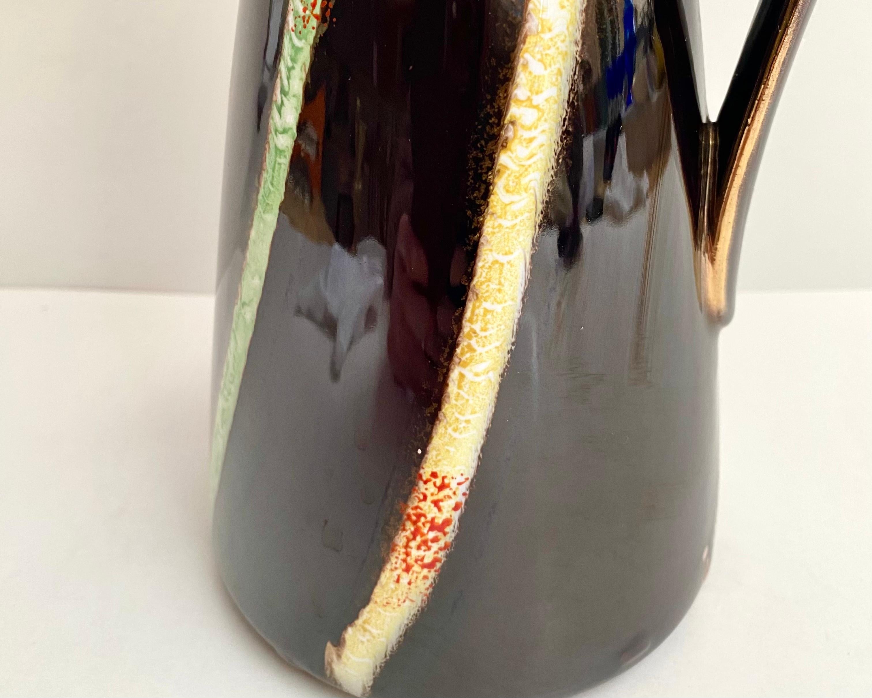 Vase vintage en céramique avec anse par Jasba Keramik de l'Allemagne de l'Ouest. 1970s. 

Ce magnifique vase de style bohème, fabriqué dans les années 70, est peint à la main dans de riches tons de terre et d'or. Vitré.

Estampillé sur le