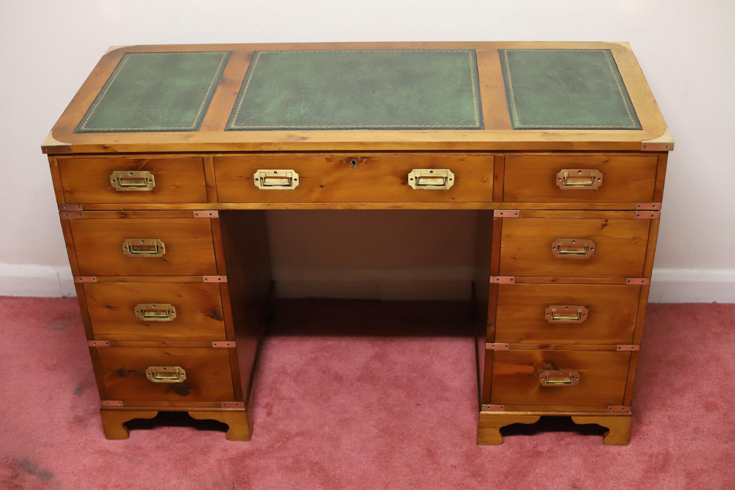 We delight to offer for sale this lovely yew wood military campaign style twin pedestal desk, rectangular top with three inset leather panels, fitted with nine drawers, brass brackets and recessed brass handles, on bracket feet. In good condition