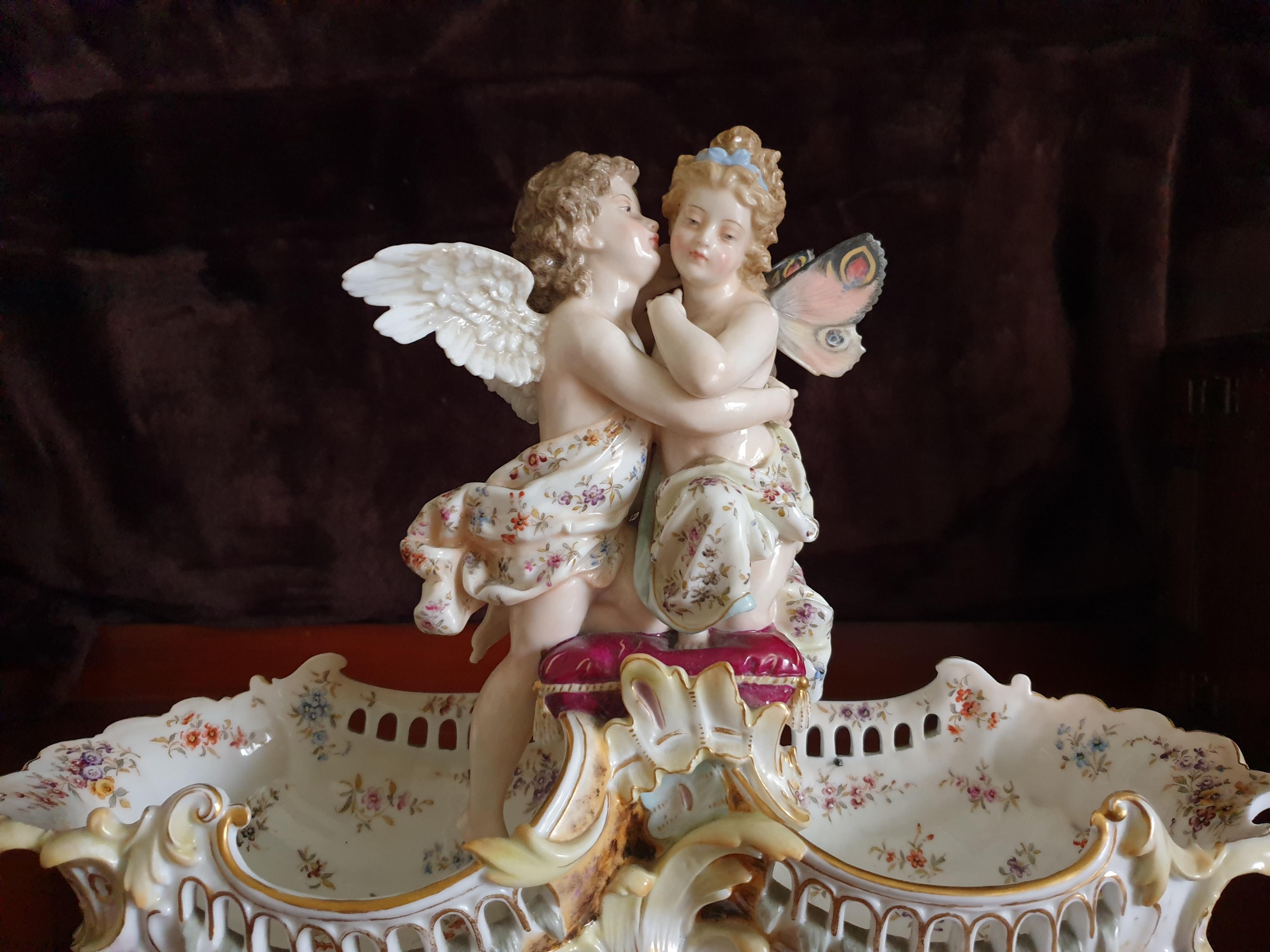 Impressive German reticulated centrepiece scene illustrates a pair of cherub lovers with finely crafted hand painted angel wings and butterfly wings, with shell panels and baskets. Hand painted in perfect condition in the manner of Meissen porcelain