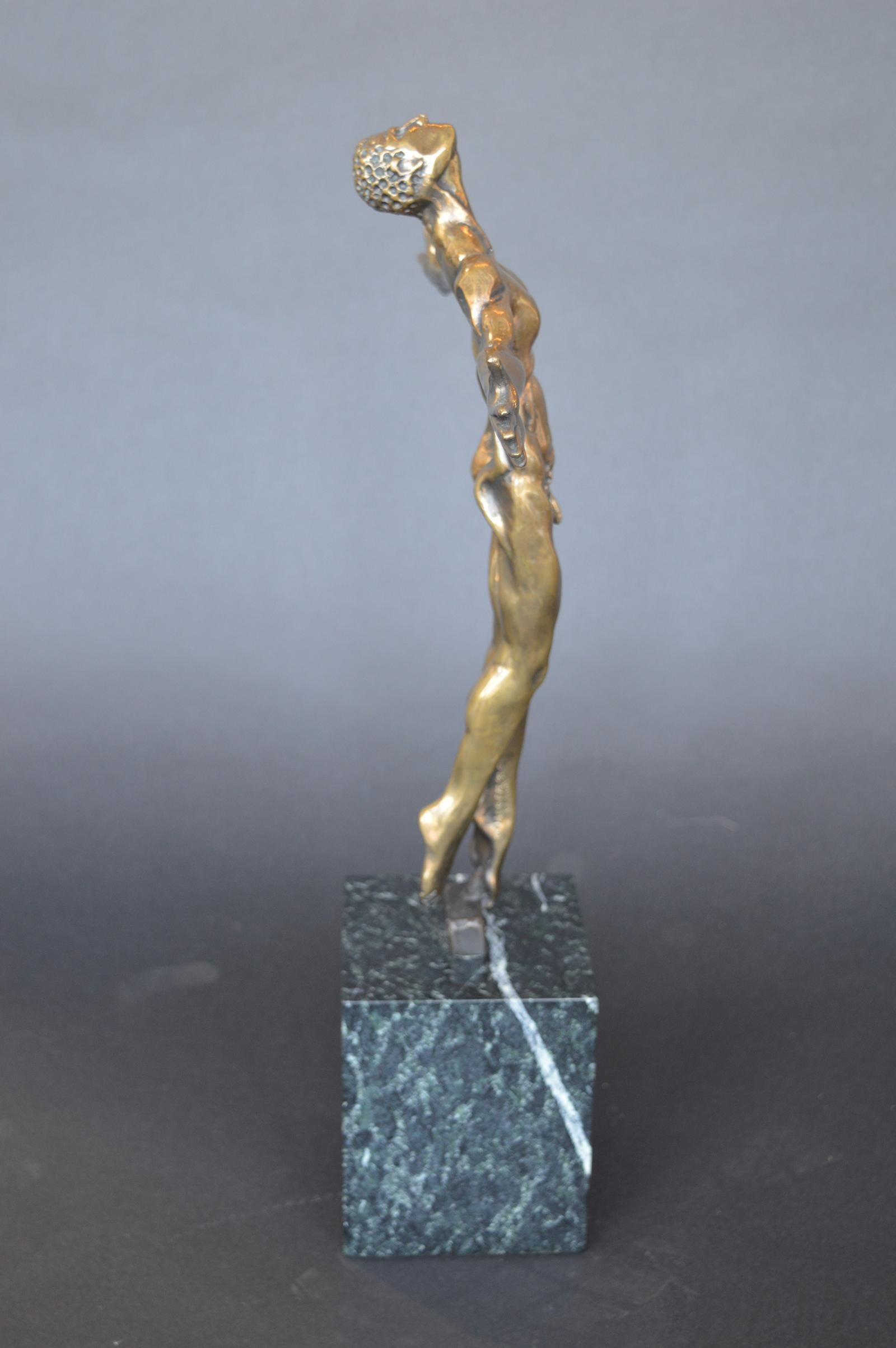 A bronze sculpture of a nude male with outstretched arms. Signed on the inner left leg, dated 1997, numbered 23/100.