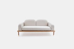 Sofá contemporáneo con base de madera maciza y detalles de latón