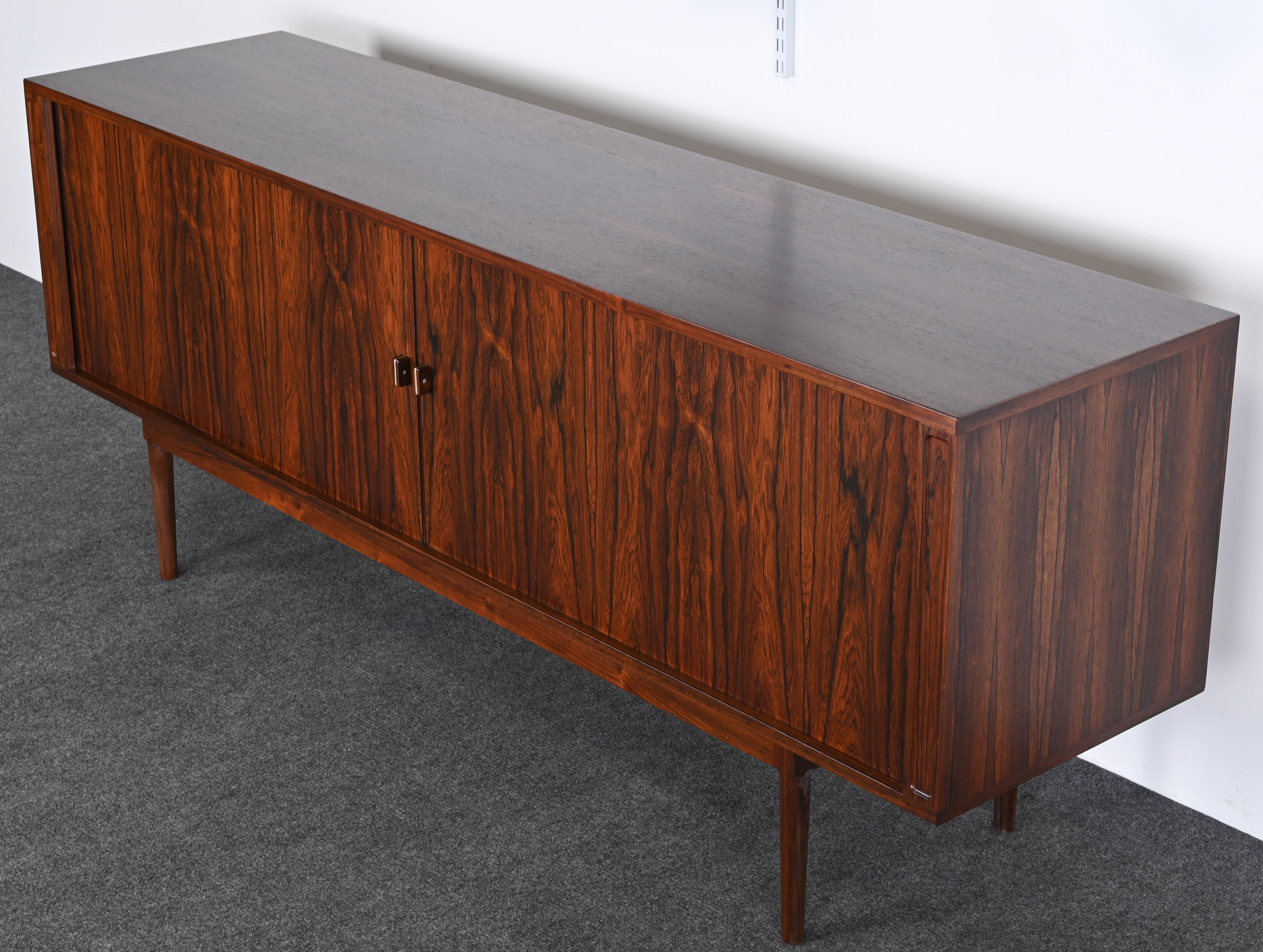 An excellent example of a rosewood sideboard designed by Peter Lovig Nielsen. The handsome rosewood credenza has much depth and graining to the veneer and the simple details of the handles are exquisite. This beautiful credenza would look great in