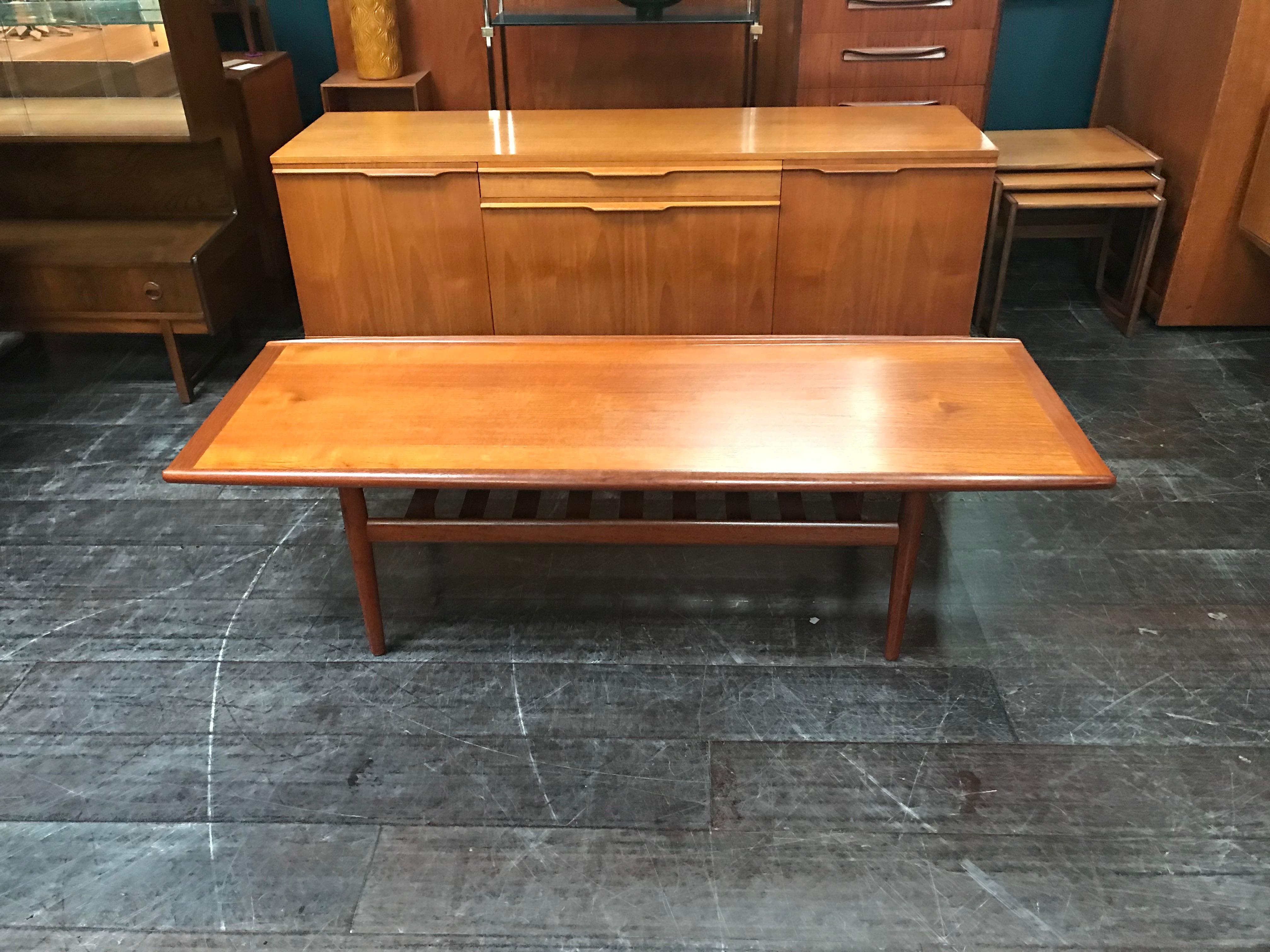 This teak coffee table was designed by Grete Jalk and manufactured by Glostrup Mobelfabrik in Denmark, probably in the late 1950s or early 1960s. It is a truly stunning, long coffee table. The softly curved shaping of the two longer edges of the