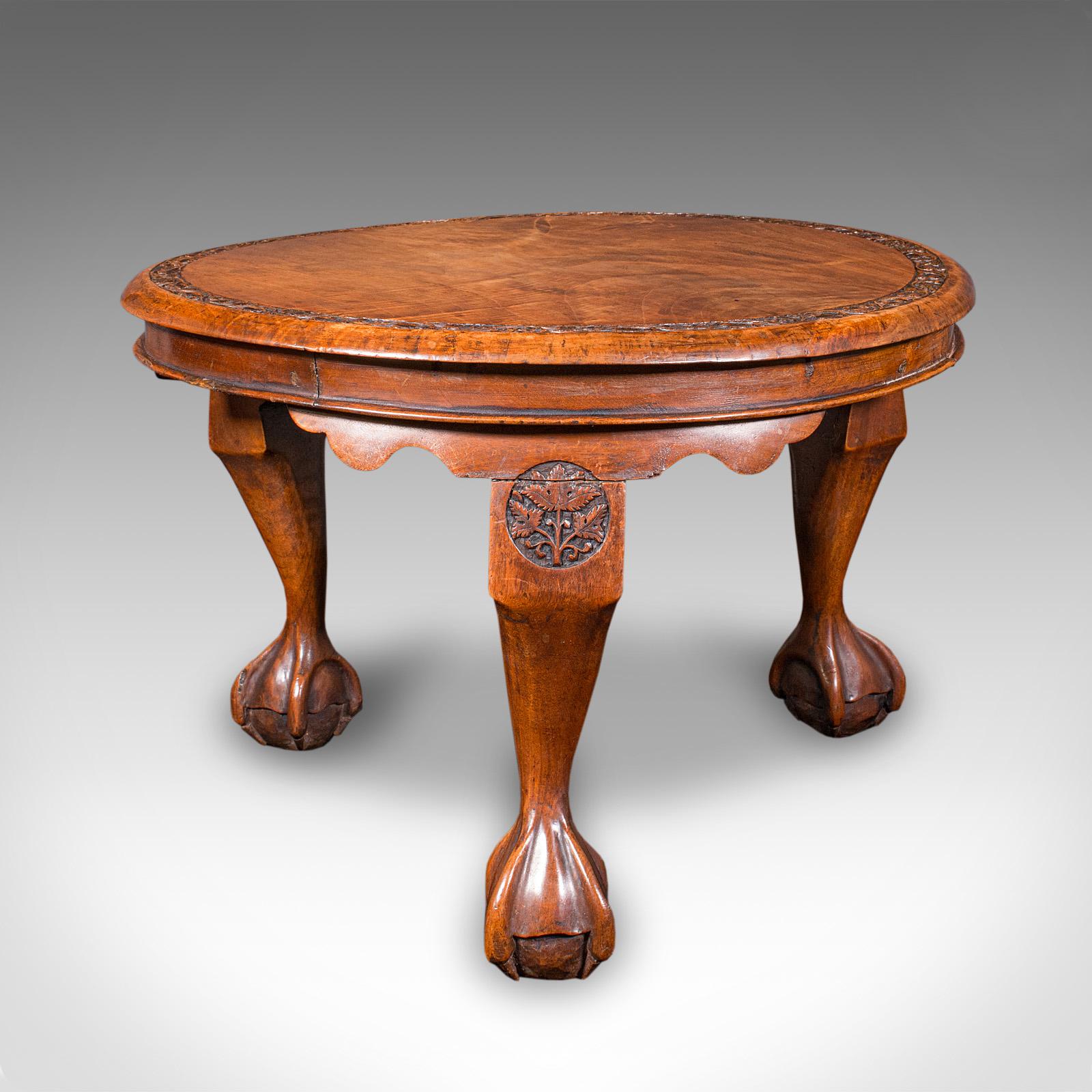 This is a low antique lamp table. An English, mahogany and beech side or tea table, dating to the late Victorian period, circa 1890. With a handsome profile and richly carved detail, this circular table makes for a delightful accent