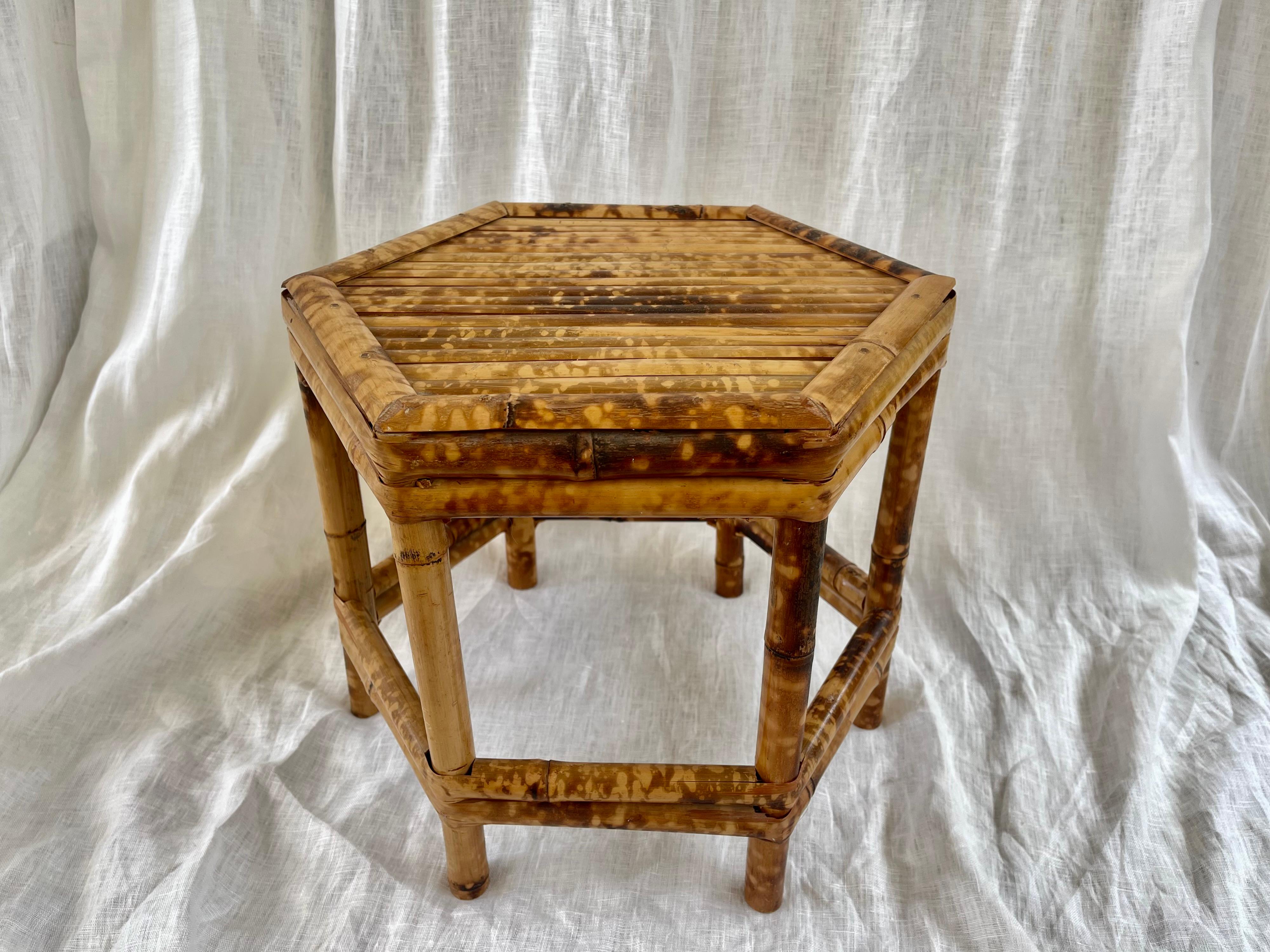 Petite table basse à piédestal en osier et bambou, fabriquée à la main, pour servir de support à des boissons ou à des plantes.
Vers 1970, en Asie.
La pièce est de forme hexagonale et présente une finition en écaille ''tortue