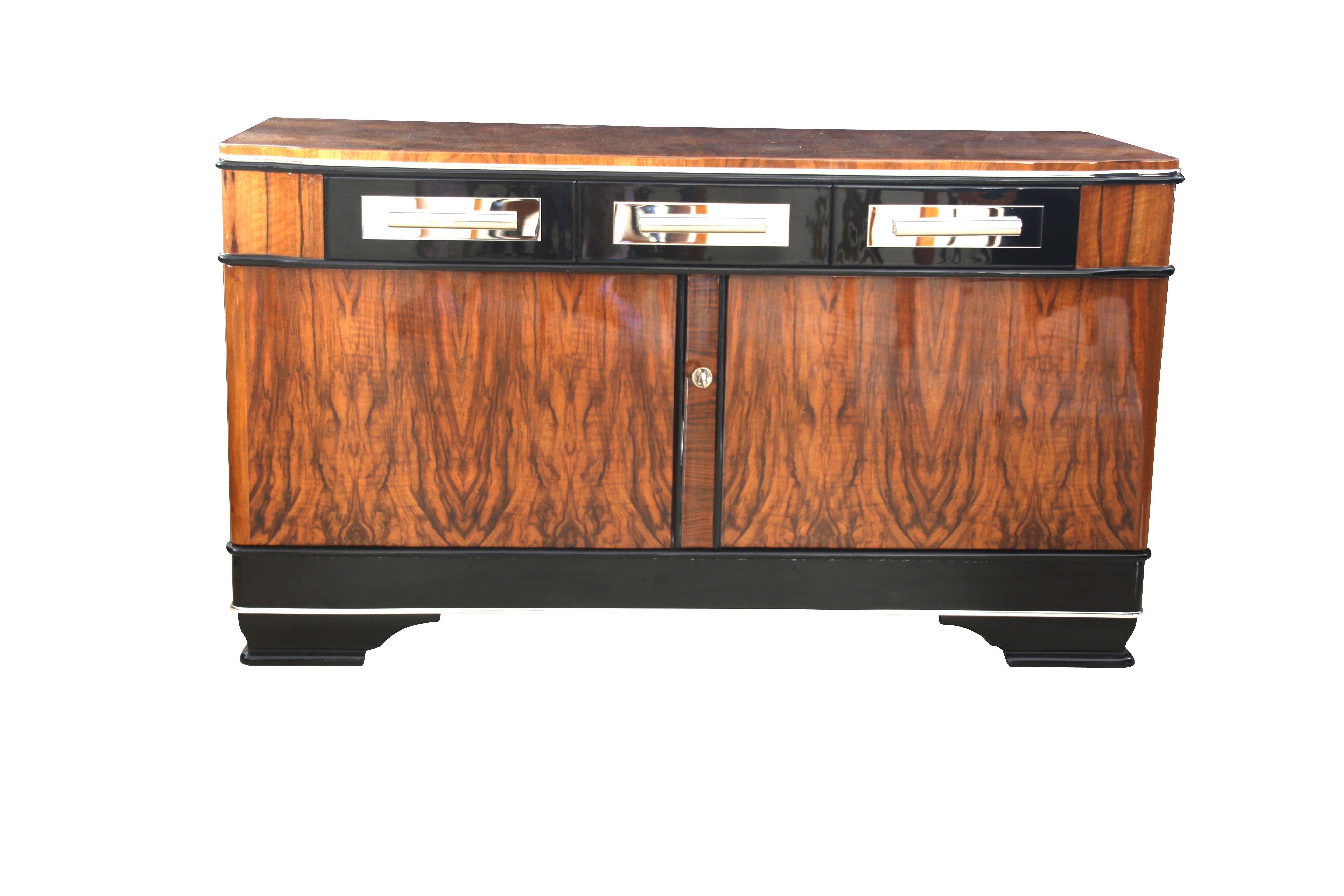 Classic Bauhaus Lowboard / Sideboard from Germany around 1930.

The furniture has a wonderful book-matched walnut veneer and partly ebonized areas.

At the front, there are two doors with three drawers above. Around the base a the top of the