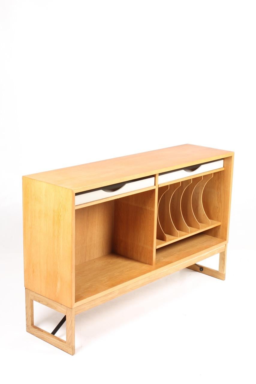 Low bookcase in oak with adjustable shelves and colored drawers. Designed by Danish architect Børge Mogensen for Karl Andersson cabinetmakers. Made in Sweden in the 1960s. Great original condition.