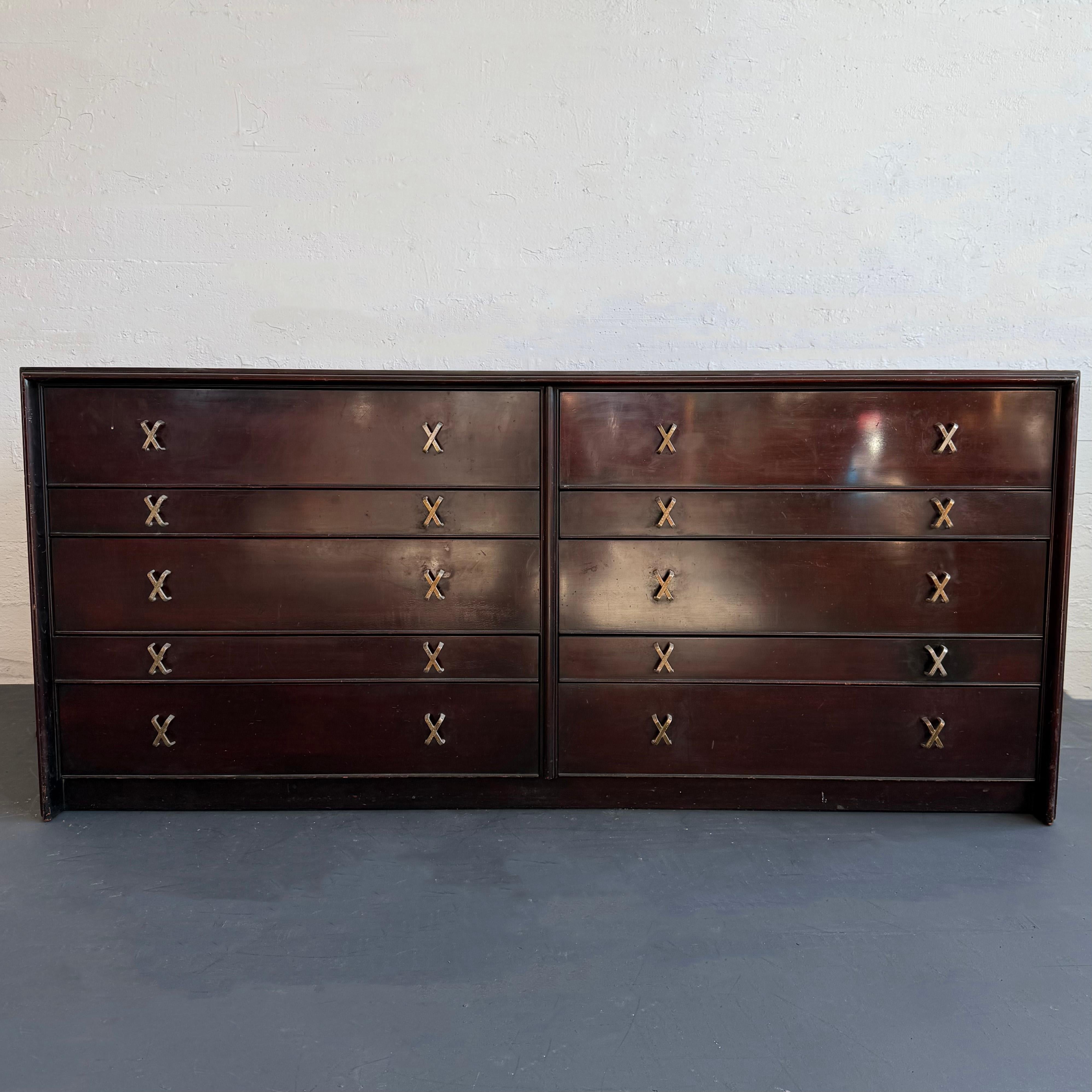 This vintage gem is designed by the iconic and prolific Paul Frankl for Johnson Furniture Co. retailed by John Stuart in the heart of New York City, circa 1950s. This double wide, low boy dresser is made of dark lacquered mahogany featuring a lovely