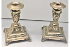 Chandeliers bas en argent repoussé et posés sur des bases carrées avec des pieds en forme de griffes.