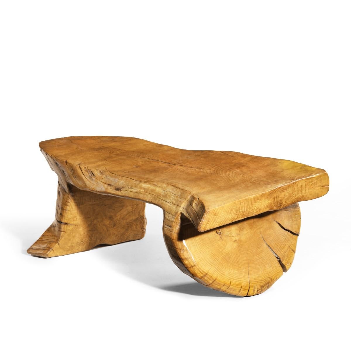 A low Maxie Lane elm coffee table, carved as one piece from the solid with on leg and the top following the curves of the trunk and the other leg cut in the round. English, circa 1970. 
  