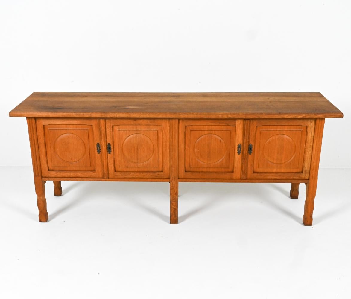 This stunning sideboard embodies the essence of Danish design during the golden age of Mid-Century Modernism. Crafted from solid oak in the 1960s and designed by the notorious Henning Kjaernulf, this sideboard exudes a timeless elegance that