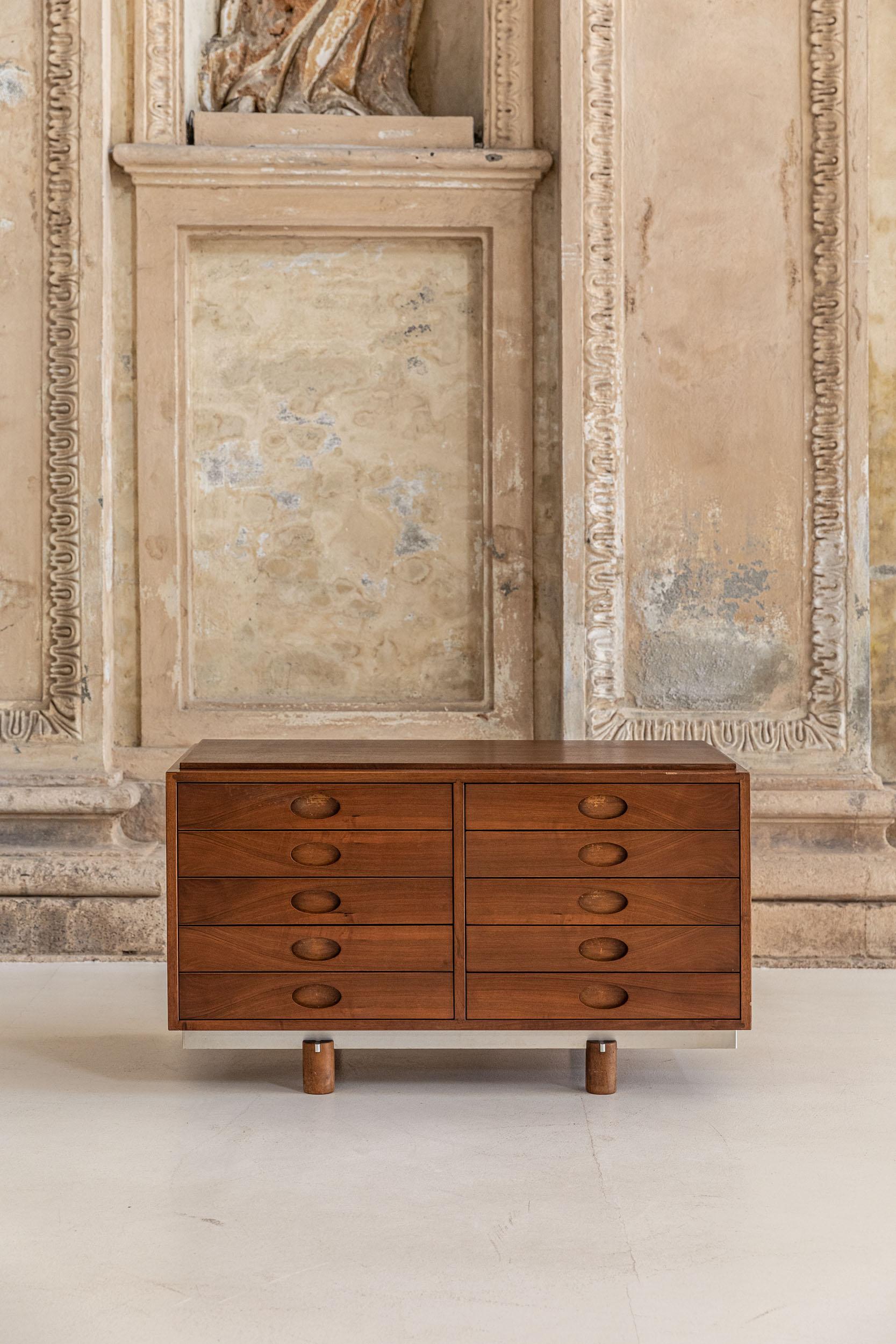 Walnut low chest of drawers designed by Gianfranco Frattini manufactured by Bernini. 
Iconic piece of Gianfranco Frattini, this elegant sideboard present five drawers for each side, with beautiful carved handles of oval shape, four cylindrical feet