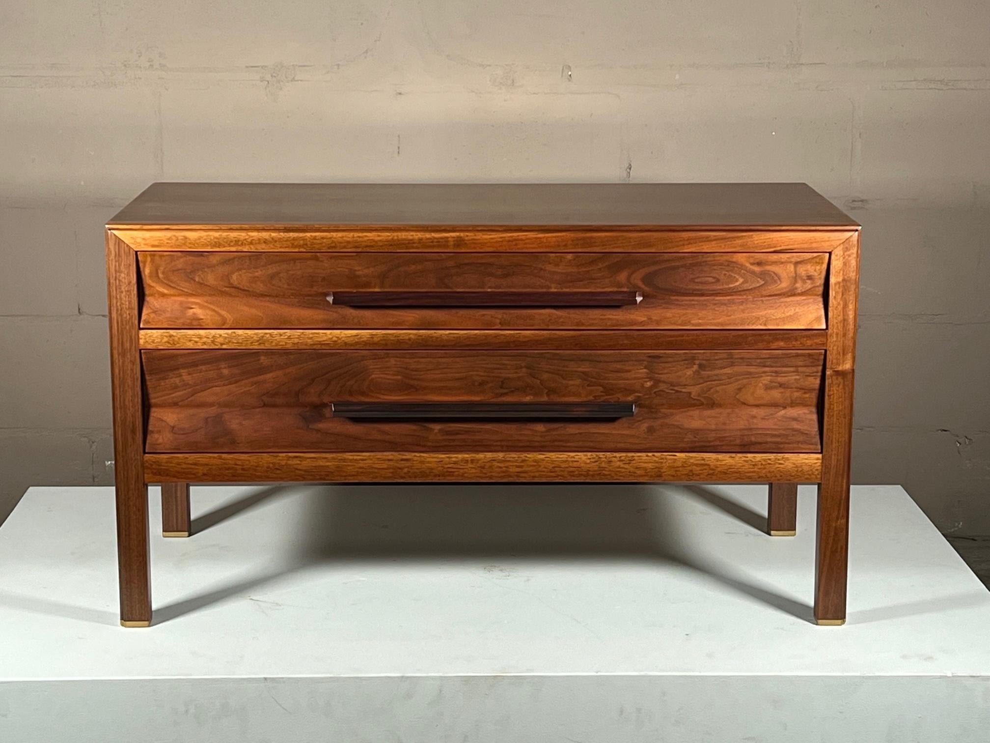 A beautiful low chest by Edward Wormley for Dunbar ca' 1960's. Walnut with excellent graining, floating long rosewood handles with a sculpted design, brass sabots. The cabinet's back is finished-so it can be placed anywhere in the room. Note the