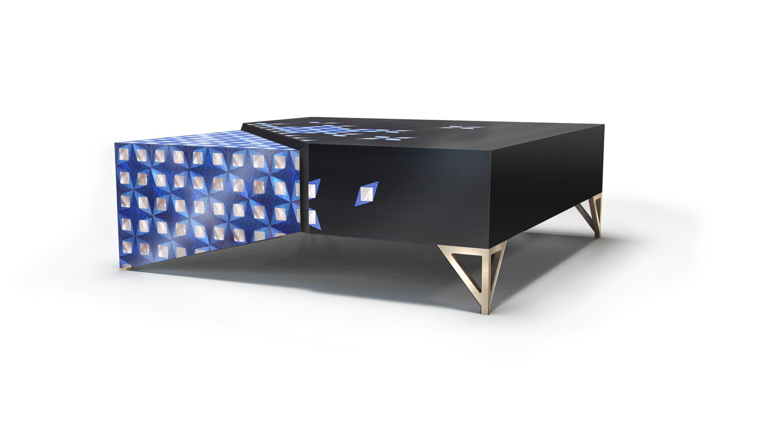 The Dark, satin finished cocktail table comes in a distinctive, hand-stained blue rippled sycamore and mother-of-pearl marquetry. It sits on handcrafted brushed brass legs with one of the corners 