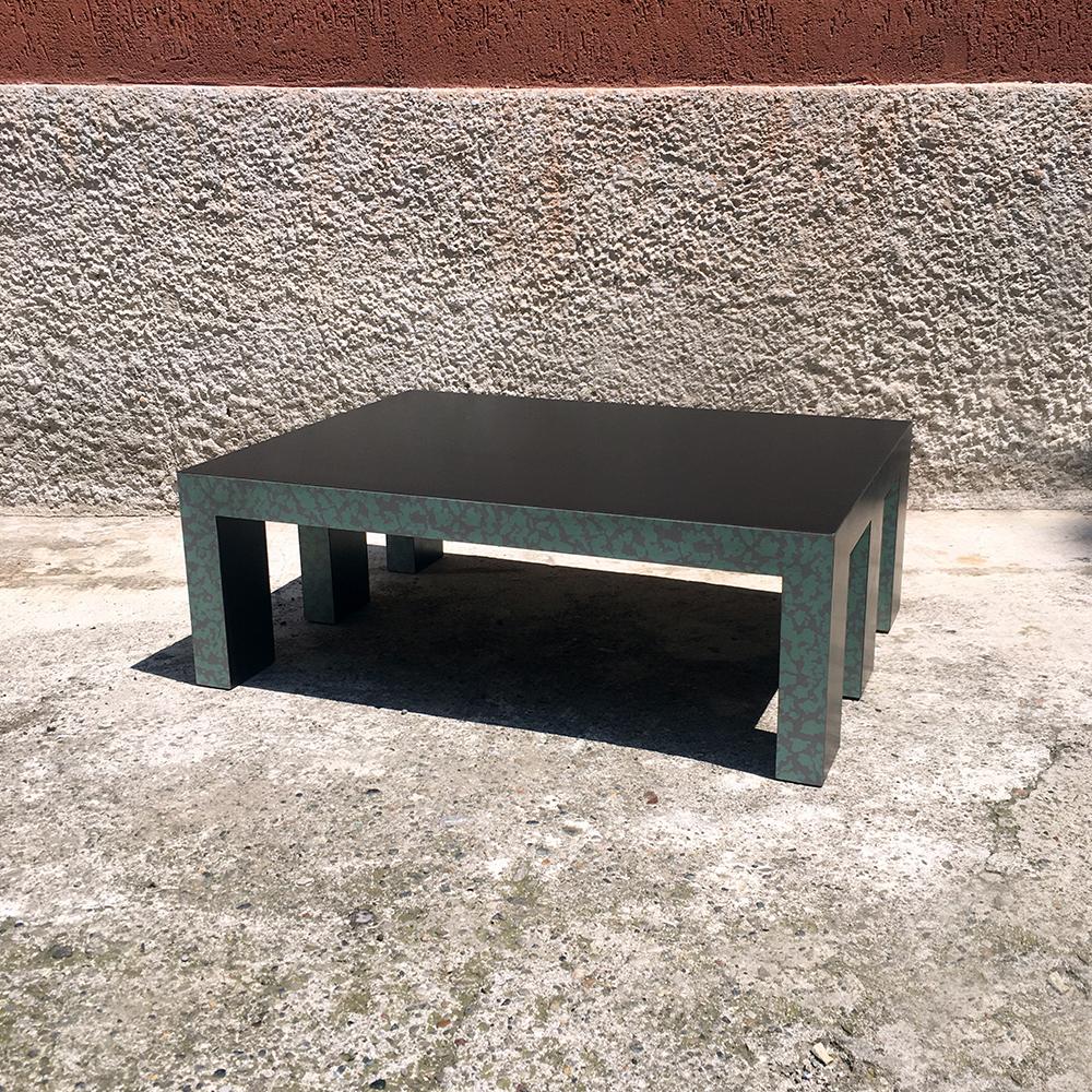 Low coffee table with green decorative motif on two side, 1980s.
Low coffee table dating to the eighties, with matt black finishing and green decorative motif on two sides of the structure, six legs with squared section, 1980s. 
Perfect