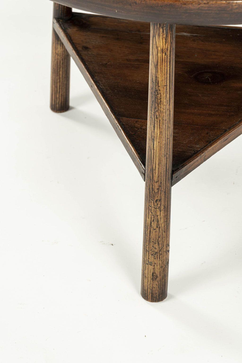 Low cricket table as side table or small coffee table. Georgian cricket table, circa 1740-1760, with thick single piece walnut table raised upon tapered round oak legs with pine under-shelf. Under-shelf surrounded by gallery edge. Height cut down at