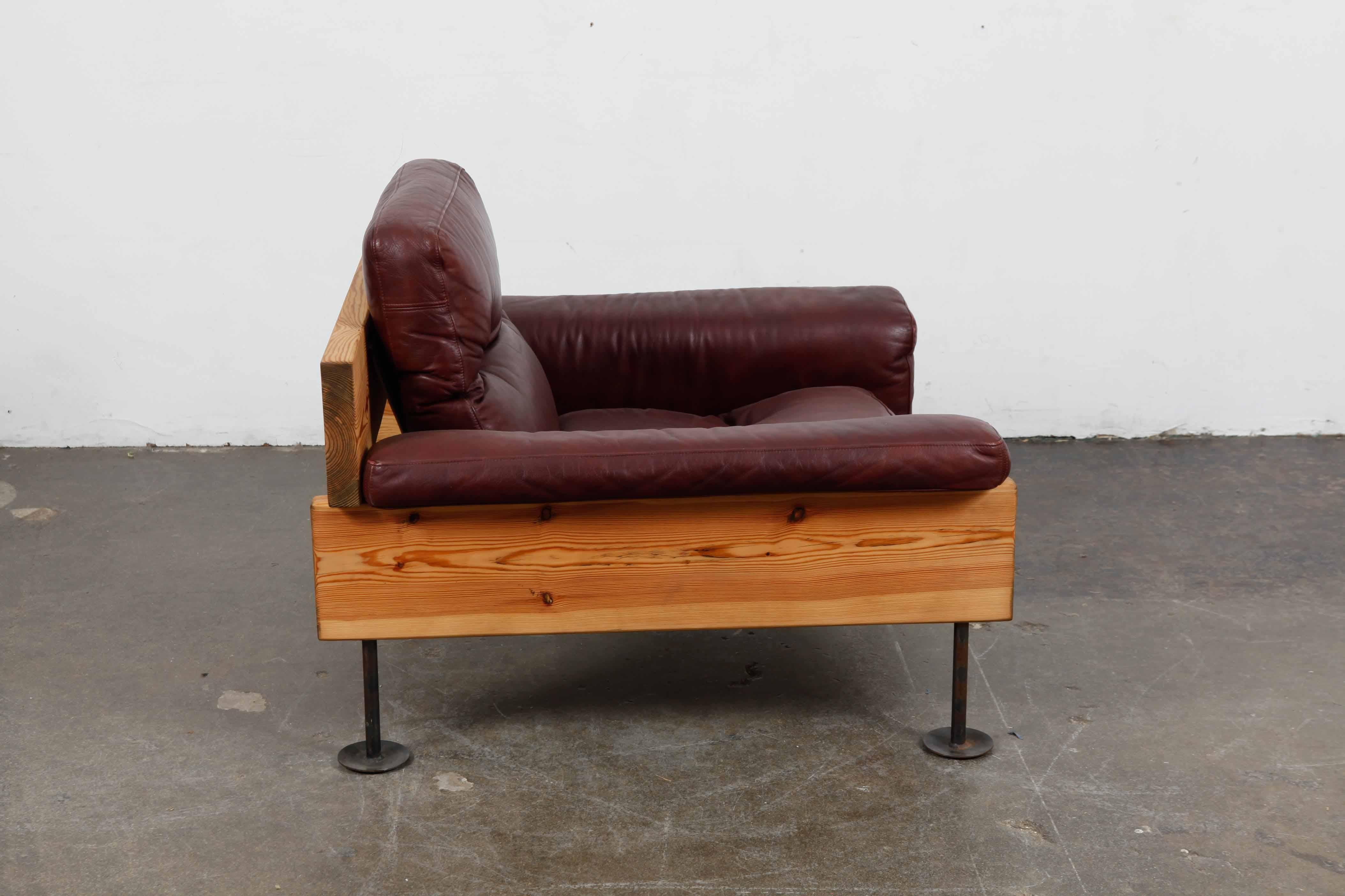 Solid pine and original oxblood leather low 1970s lounge chair with metal legs, designed by Hannu Jyräs of Finland and produced by Peem Oy.