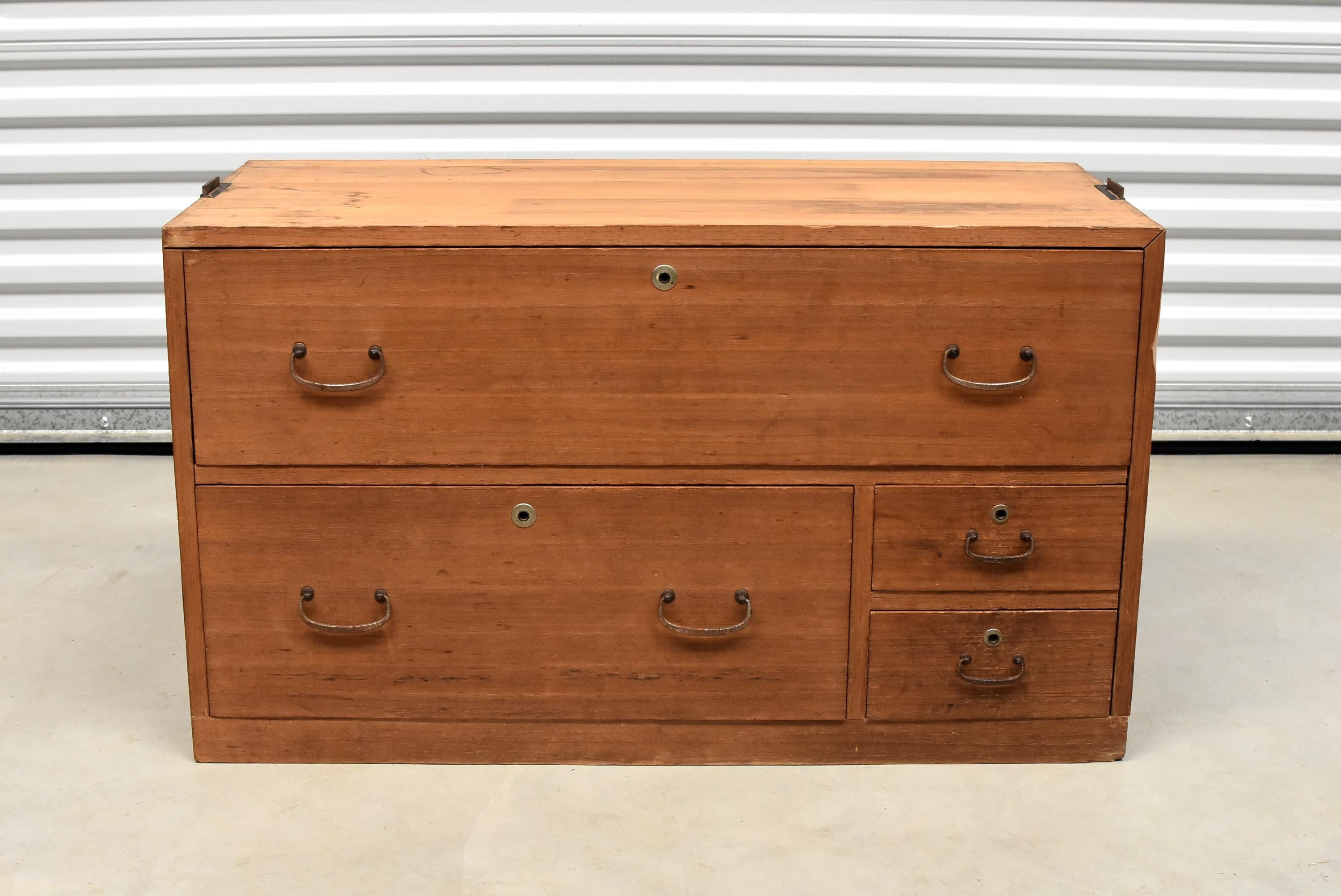 An elegant vintage Japanese Tansu in natural finish. Beautiful solid wood. Simple, elegant, solid brass hardware. Four drawers in great condition. Natural finish makes the piece versatile in any interior. Retractable solid iron side handles make