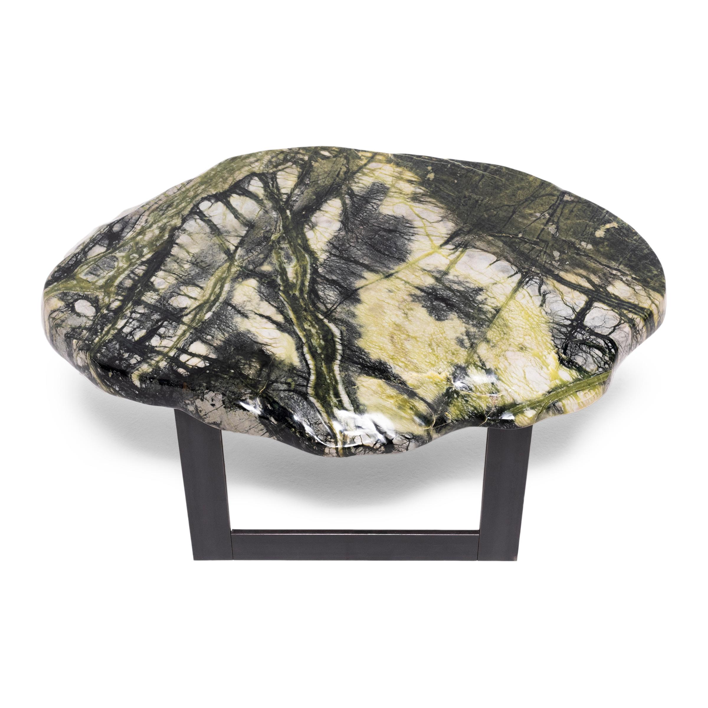 Prized by ancient scholars, meditation stones invigorated the imaginations of poets, painters, and calligraphers. The abstract shape and veining of the greenery stone specimen that tops this table is composed of jadeite, moss agate, serpentine, and
