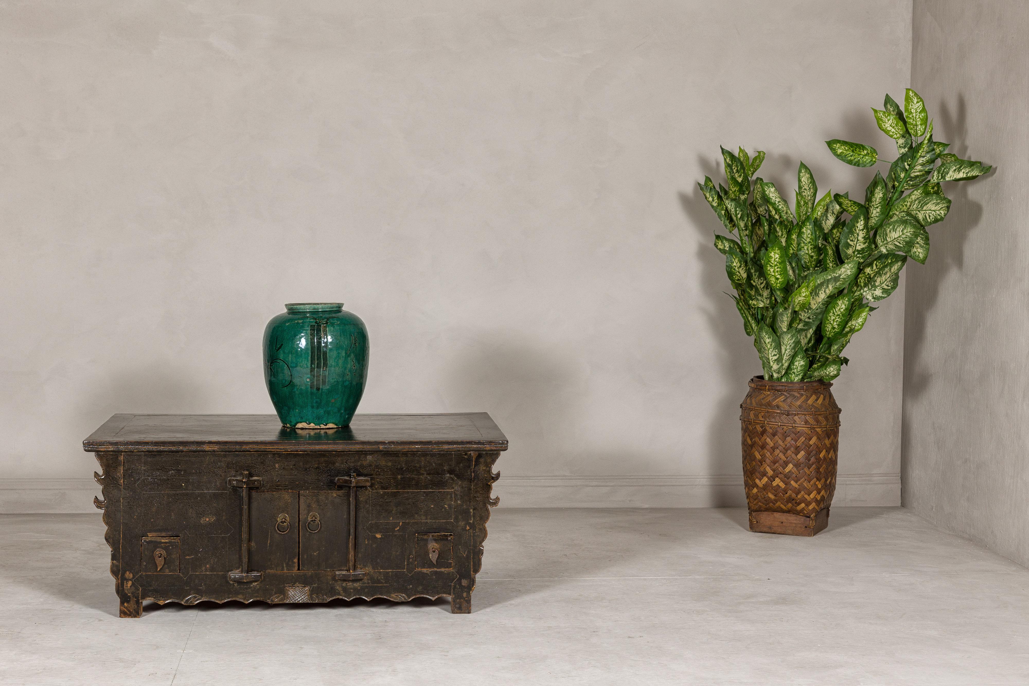 A low Kang Qing Dynasty period sideboard from the 19th century with brown distressed finish, two small doors, two small drawers and teardrop brass hardware. Step into a world of historical elegance with this Qing Dynasty period Kang sideboard, a