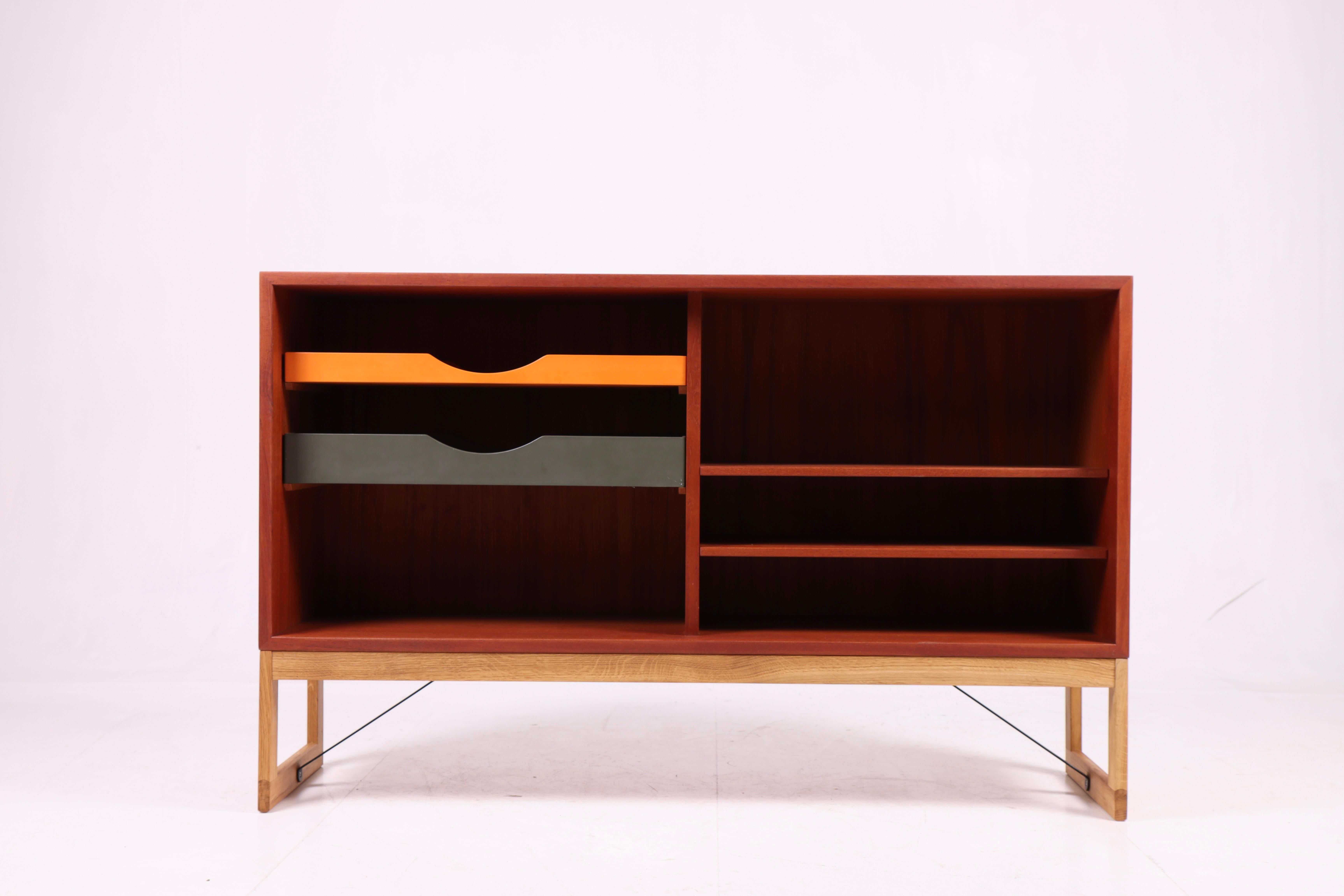 Low bookcase in teak with adjustable shelves and colored drawers. Designed by Danish architect Børge Mogensen for Karl Andersson cabinetmakers. Made in Sweden in the 1960s. Great original condition.