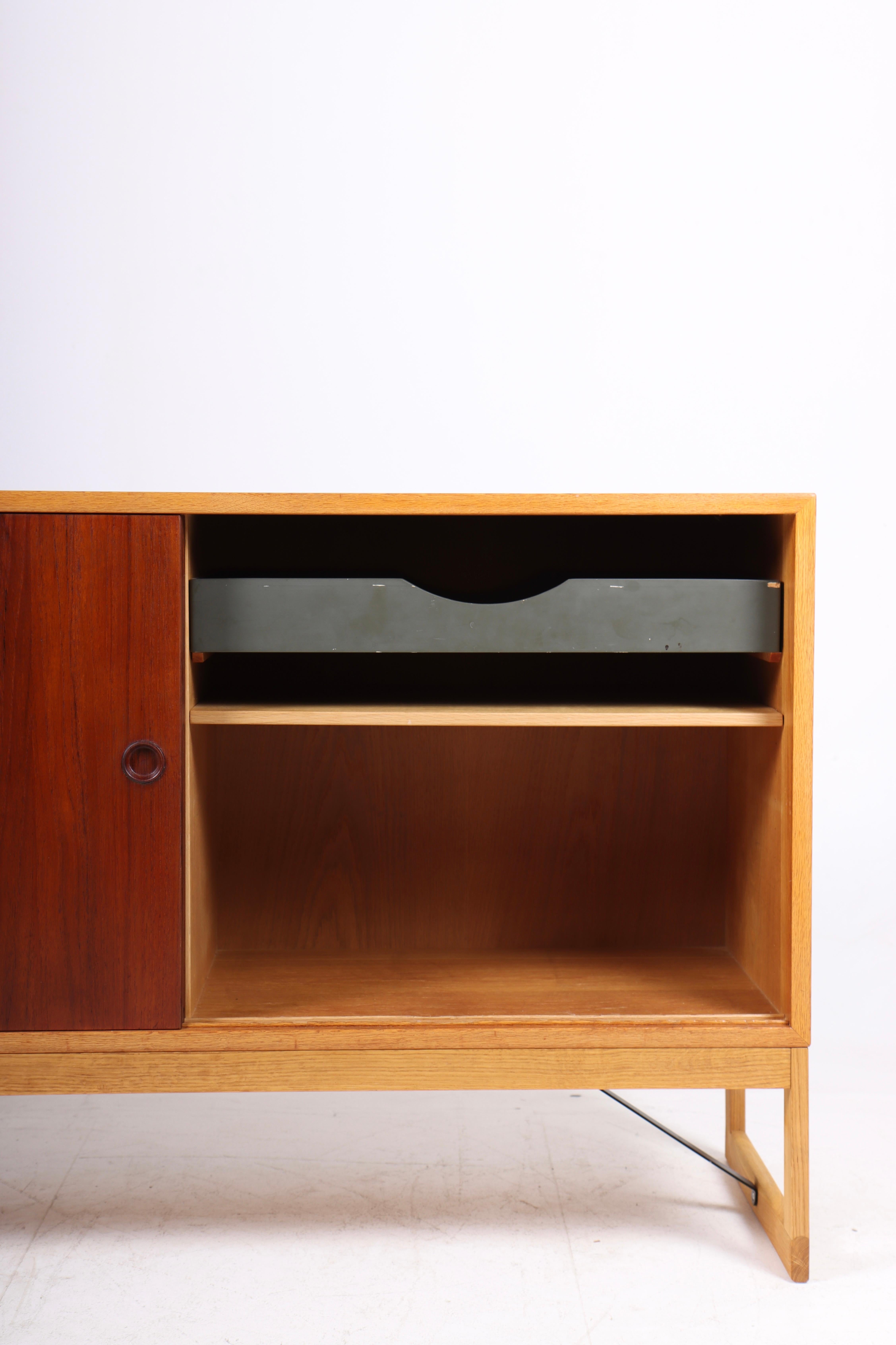 Low cabinet in oak with teak doors. Designed by Danish architect Børge Mogensen for Karl Andersson cabinetmakers. Made in Sweden in the 1960s. Great original condition.