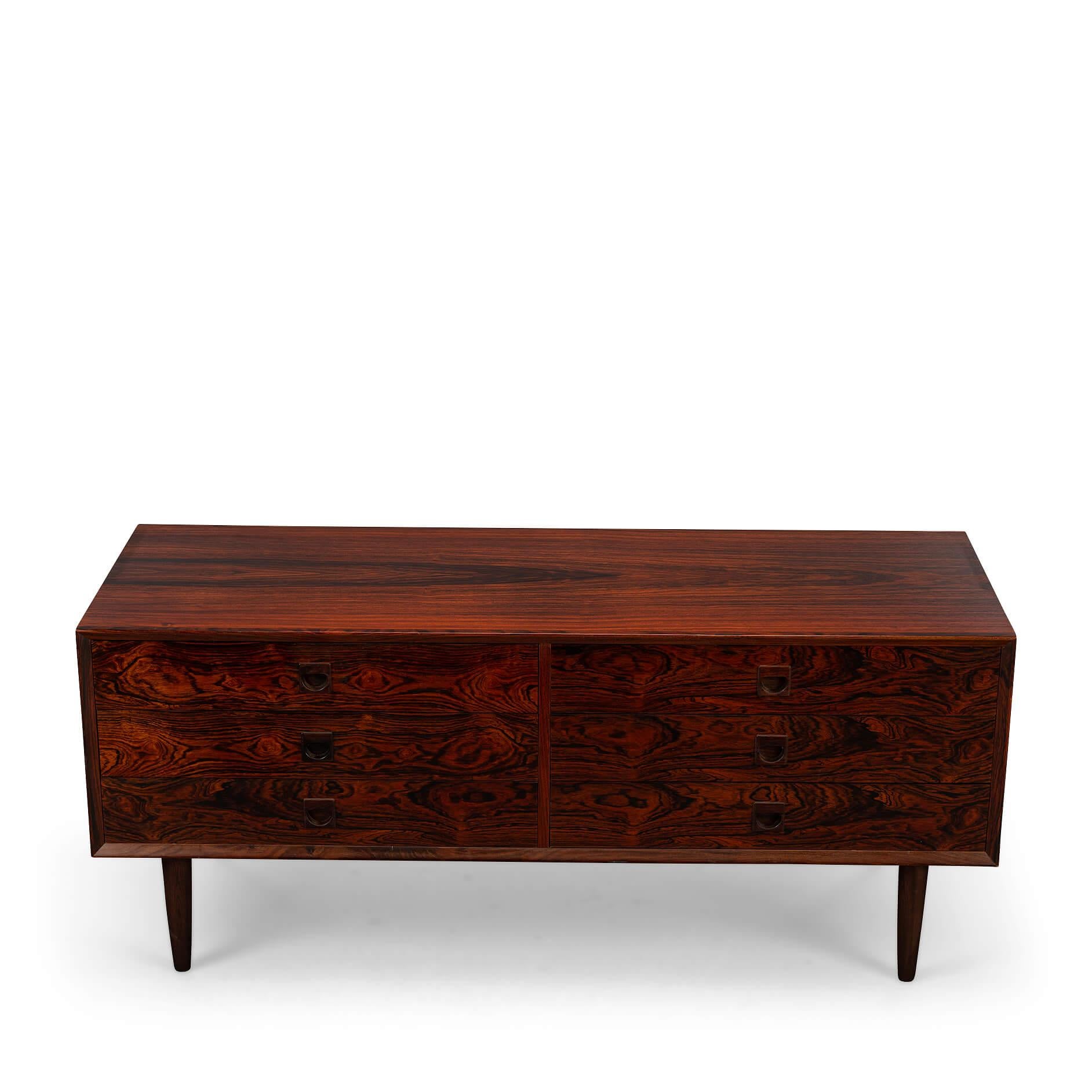Rosewood chest of drawers
A beautiful low chest of drawers by Brouer made of expressive rosewood. The color is a beautiful reddish darkbrown. The cool grips and patterning of the wood make this one a true eye catcher. The top left drawer is covered