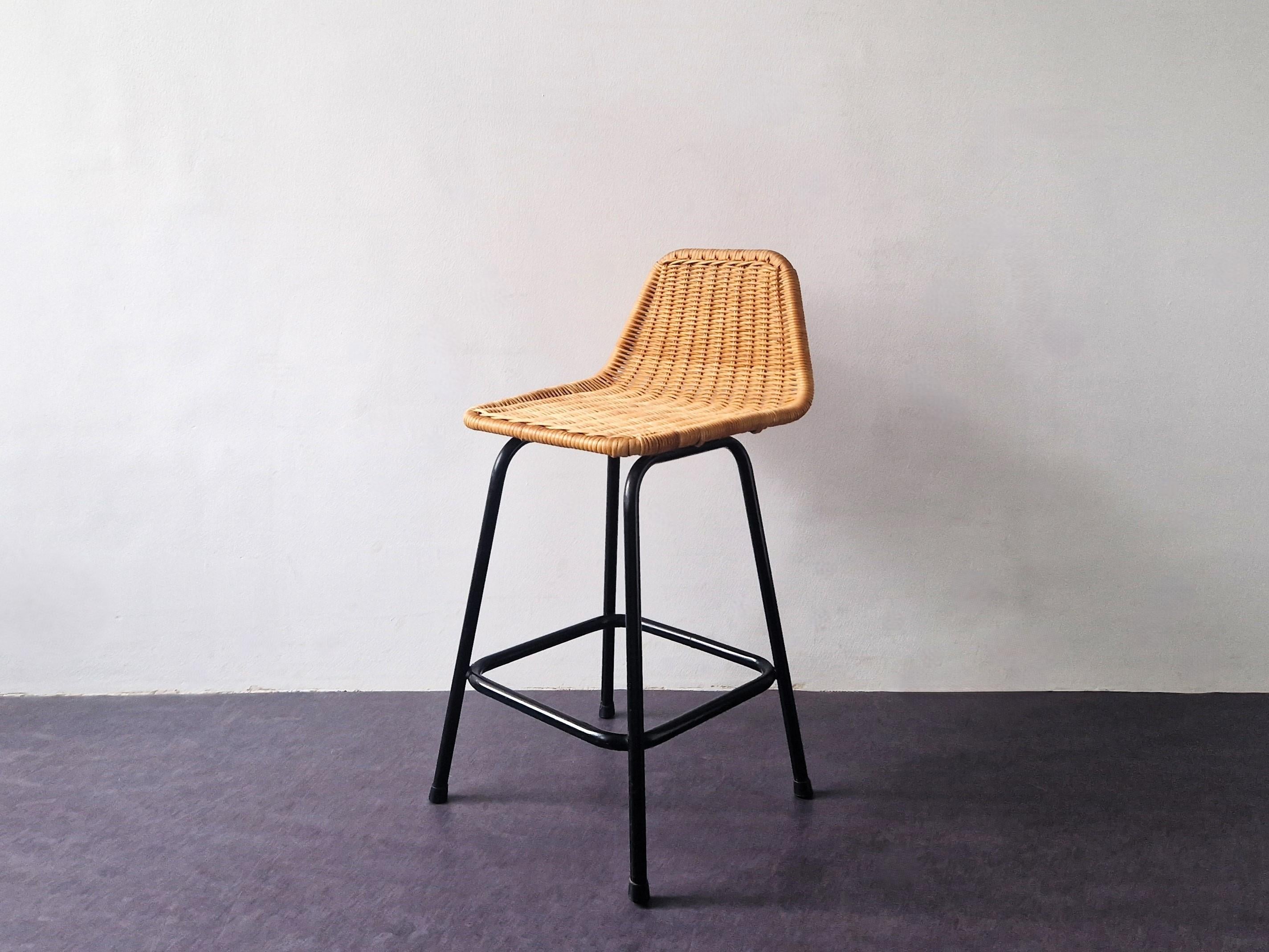 This low model stool was made by Rohé Noordwolde in the 1960's. It has a black lacquered metal frame with a wicker seat. The black laquered frame gives a nice contrast to the rattan. This bar stool is in a very good condition with small signs of age
