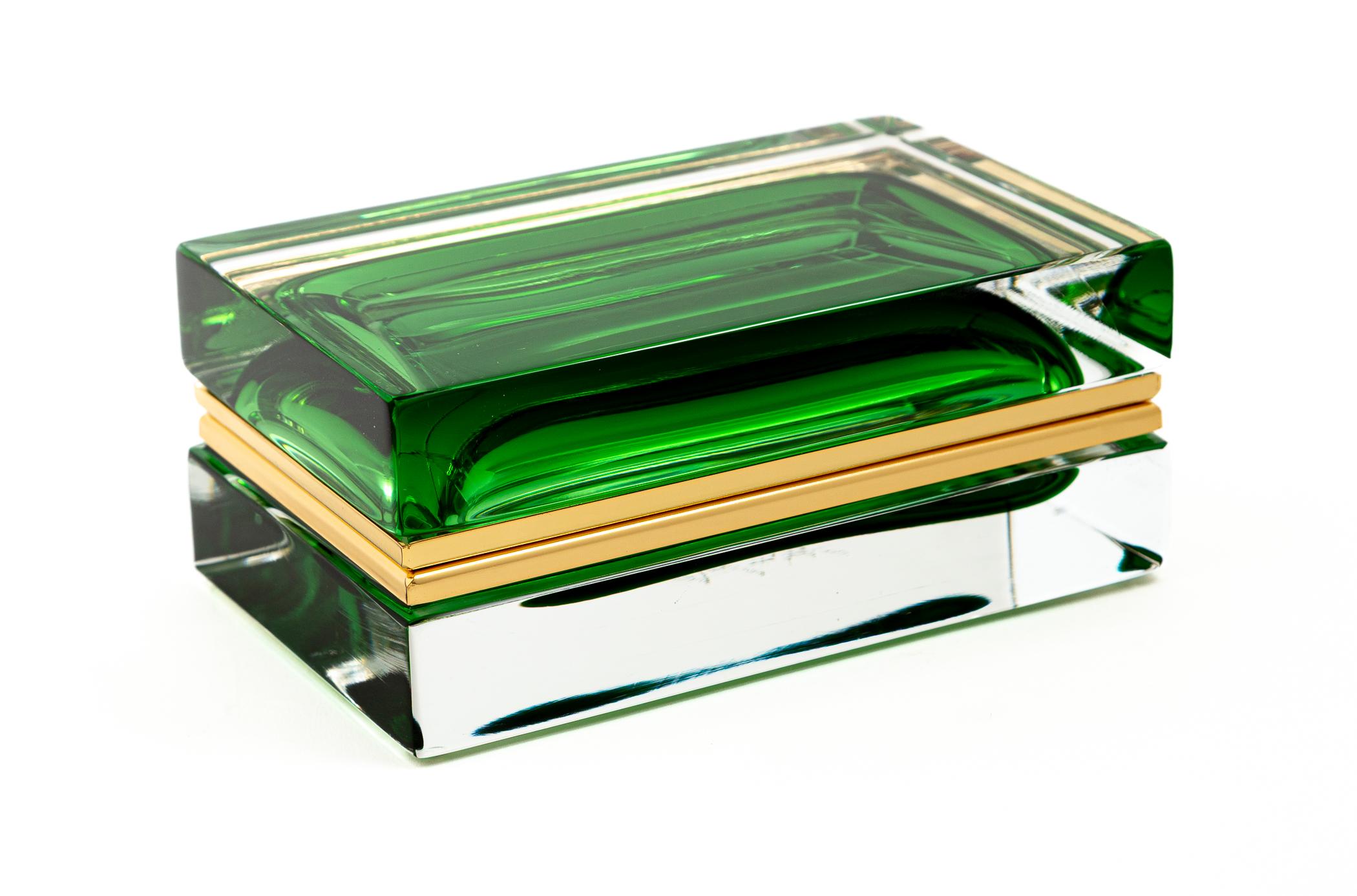 Boîte en verre soufflé de Murano, unique en son genre, de forme rectangulaire, avec un couvercle flottant.  Le centre de l'orbe vert crée un bel effet sculptural.  avec ses propres accessoires personnalisés en or 14 k sur laiton.
Les boîtes sont