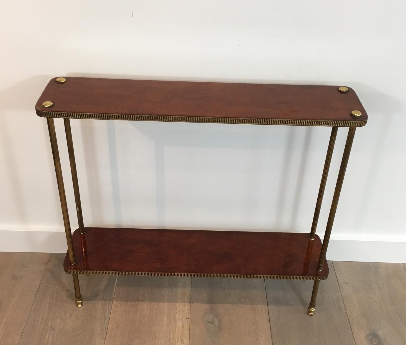 Low neoclassical mahogany and brass shelf with fluted legs, French, circa 1940.
