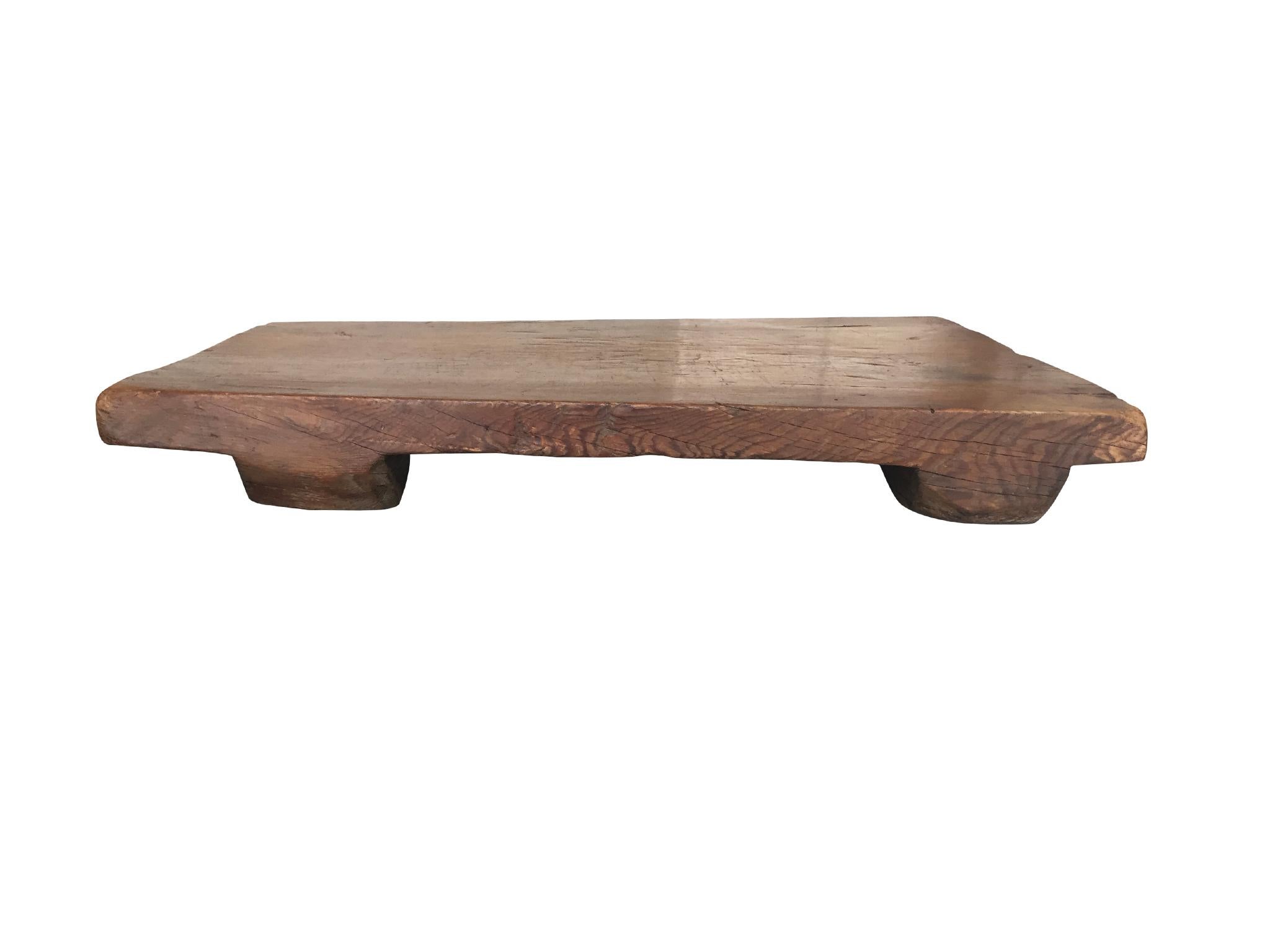 A contemporary low plinth table in the spirit of Axel Vervoordt. The style is very simple and keeps to the raw material quality of elmwood, which has a warm red-brown tone. What makes this table special is its organic shape and surface. A beautiful