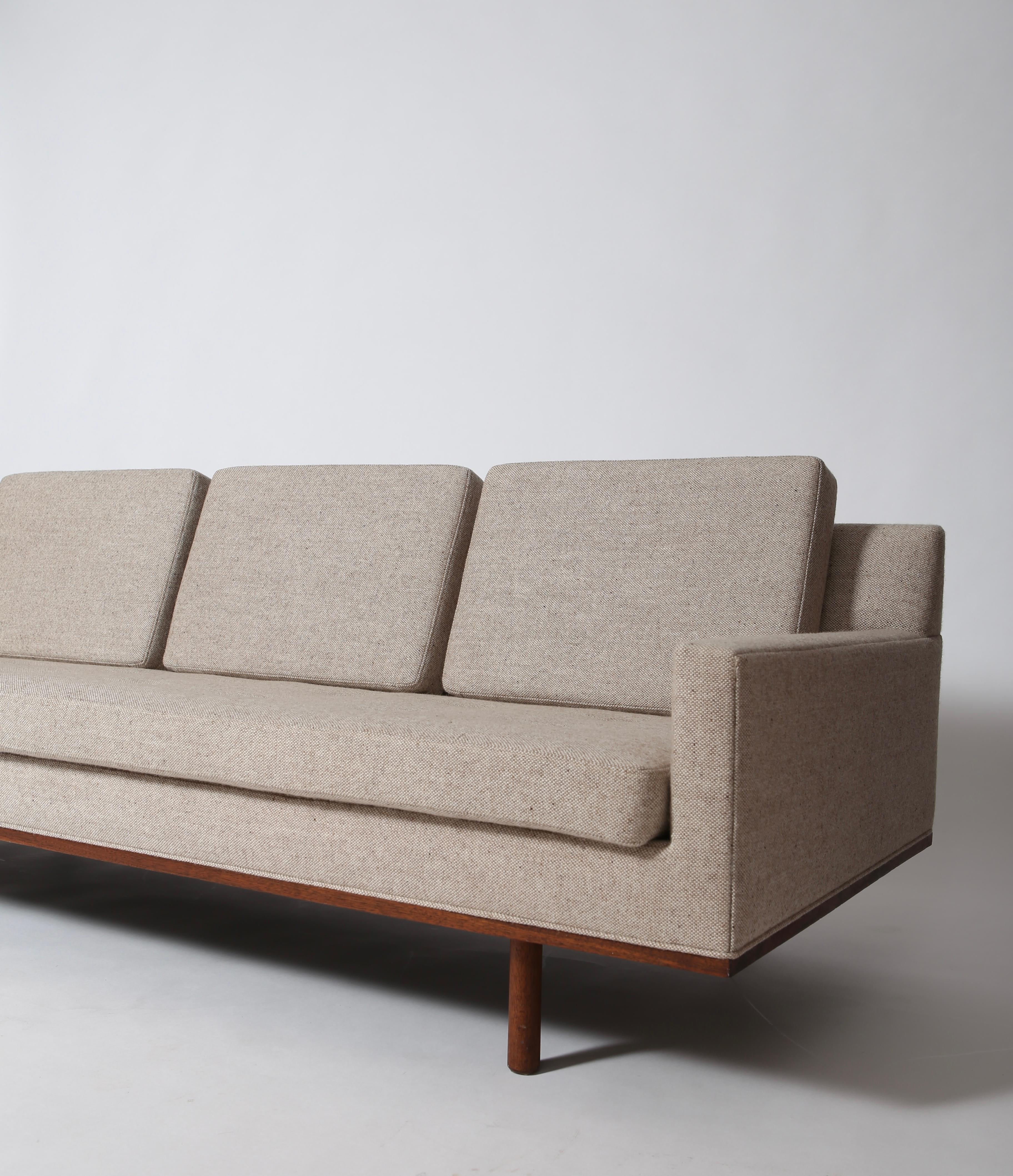 Low-profile tuxedo style mid-century sofa on floating walnut base with gorgeous lines. Reupholstered in a neutral and durable 100% woven wool textile by Knoll. Great size for smaller spaces and very nicely restored. Designed by Jules Heumann for