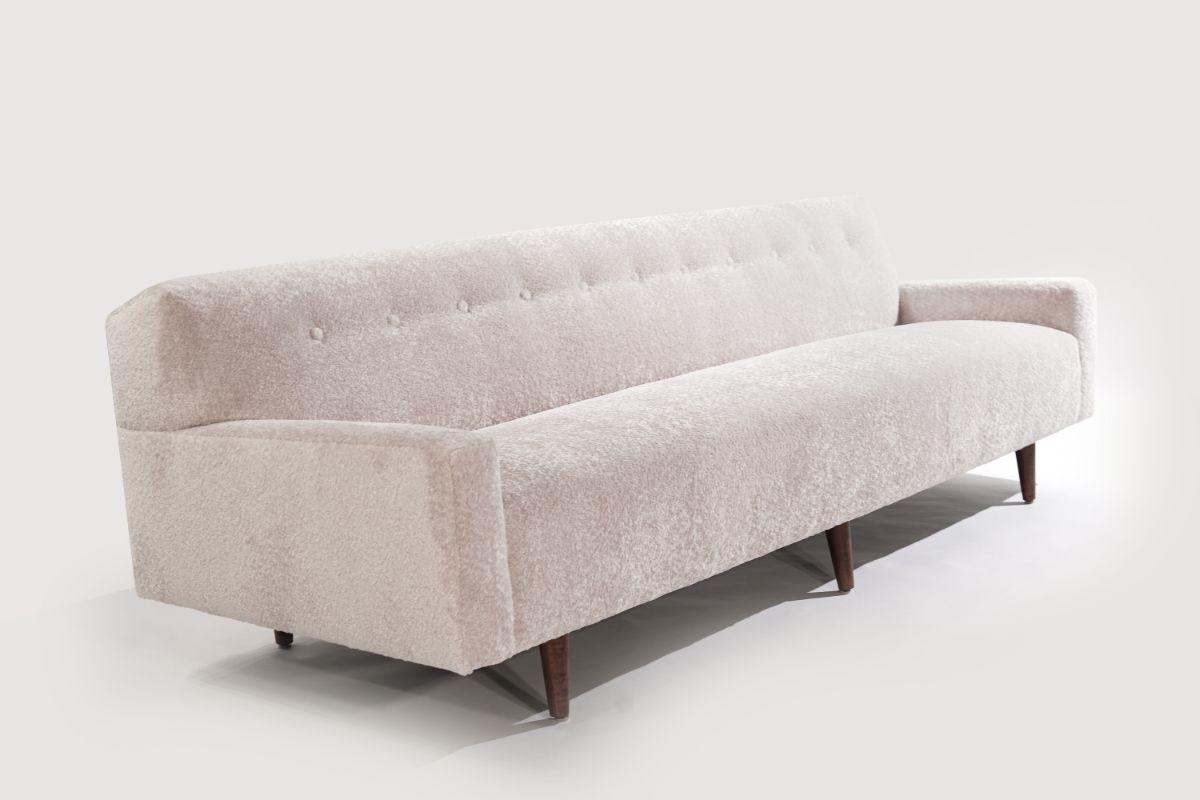 A low-profile sofa designed by Edward Wormley for Dunbar, circa 1950s. Features plush back and seat offering extreme comfort. Reupholstered in soft wool by Holly Hunt, walnut legs fully restored.

Other designers from this period include Paul