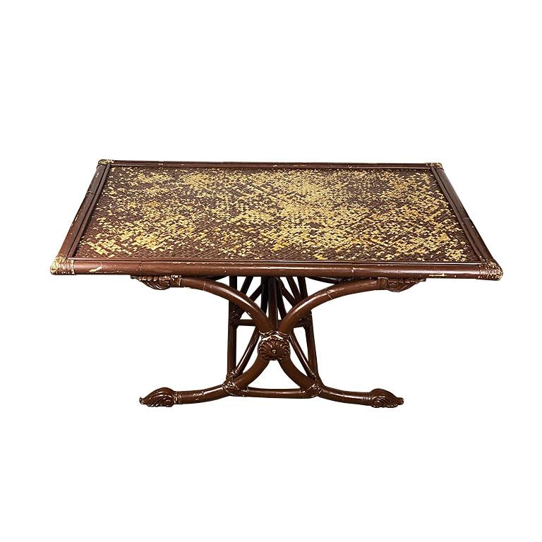 A low rectangular rattan and bamboo coffee table. This vintage coffee table is low, and perfect for entertaining. It is created from woven rattan and bamboo, and features applied rose medallions on each side. Its base is made from two bentwood