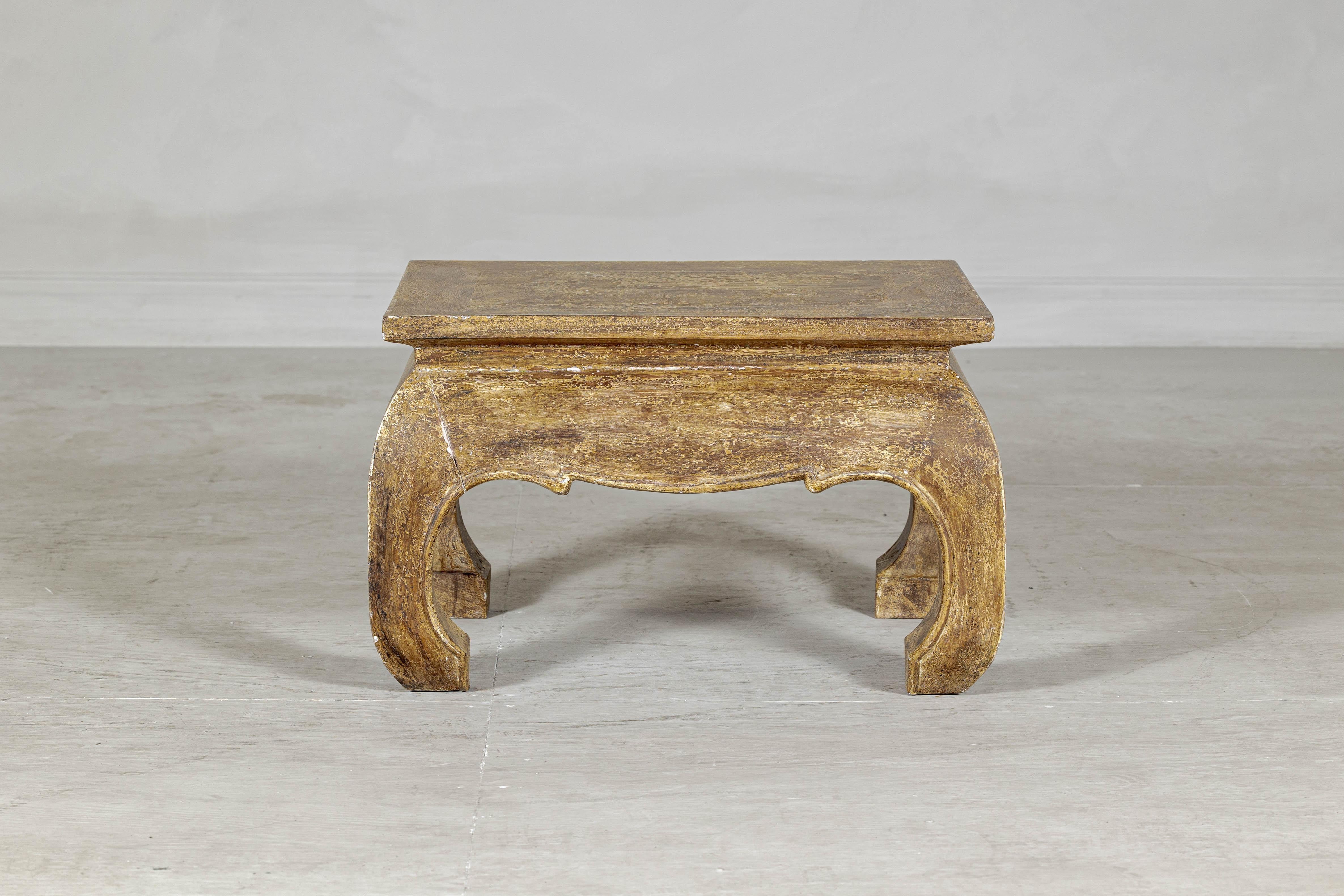 With its sculptural silhouette and aged surface, this vintage low side table brings a grounded, decorative presence to any space. The design features a rectangular top with waisted apron, resting on four substantial chow legs—each one curving inward