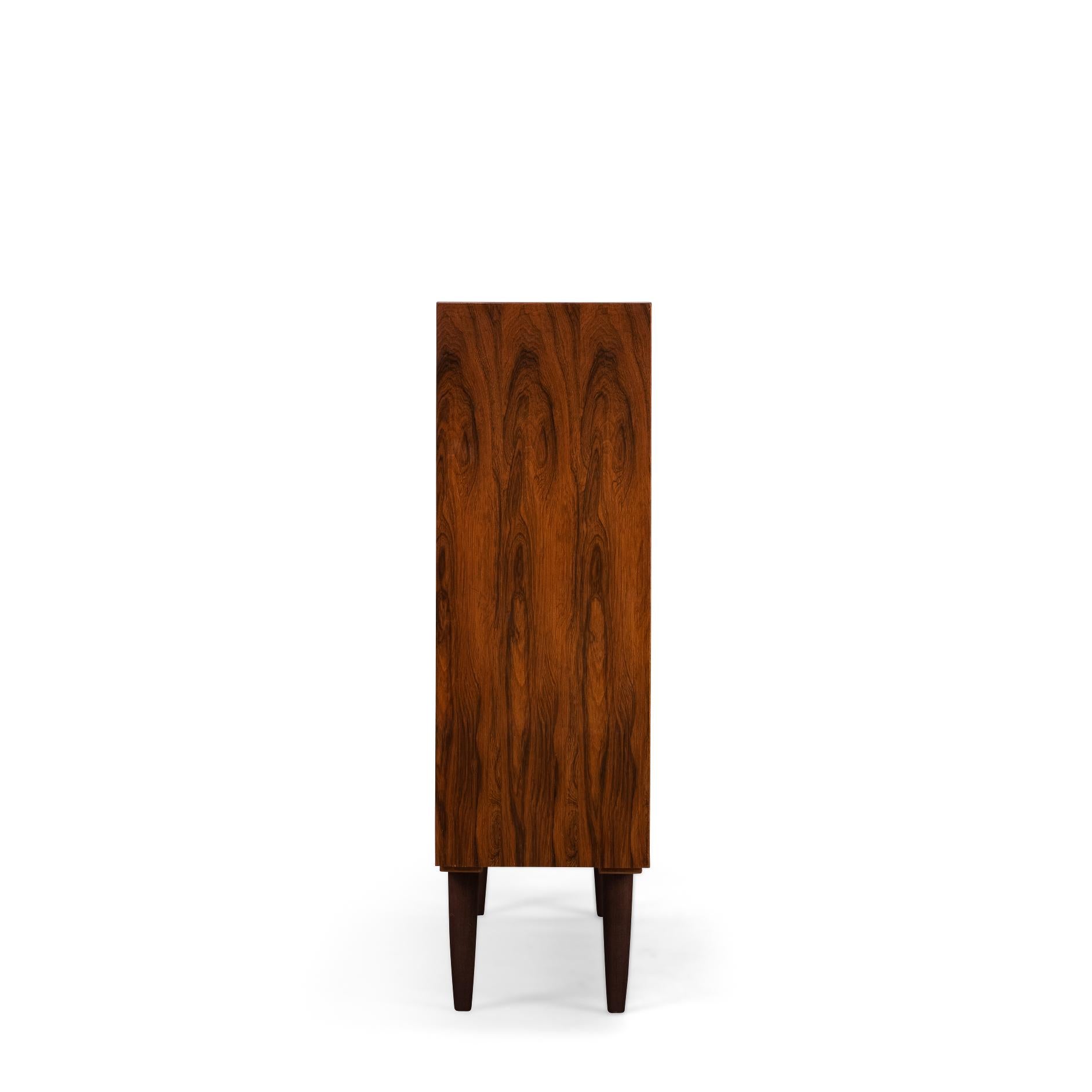 Danish low bookcase in beautiful rosewood veneer. Designed by Carlo Jensen and made by Hundevad & Co. Unfortunately, the sticker has been lost over the years. However, a Hundevad bookcase can always be recognized by the planks that are