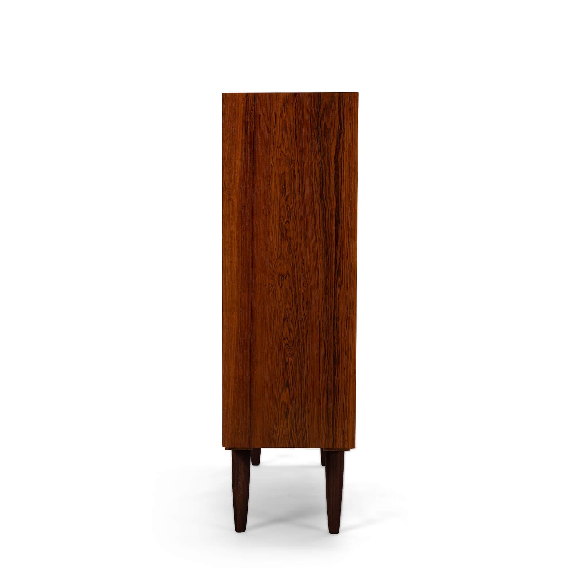 Danish tall bookcase in beautiful rosewood veneer. Designed by Carlo Jensen and made by Hundevad & Co.

This bookcase is in very good vintage condition and has a total of 4 height-adjustable shelves.

