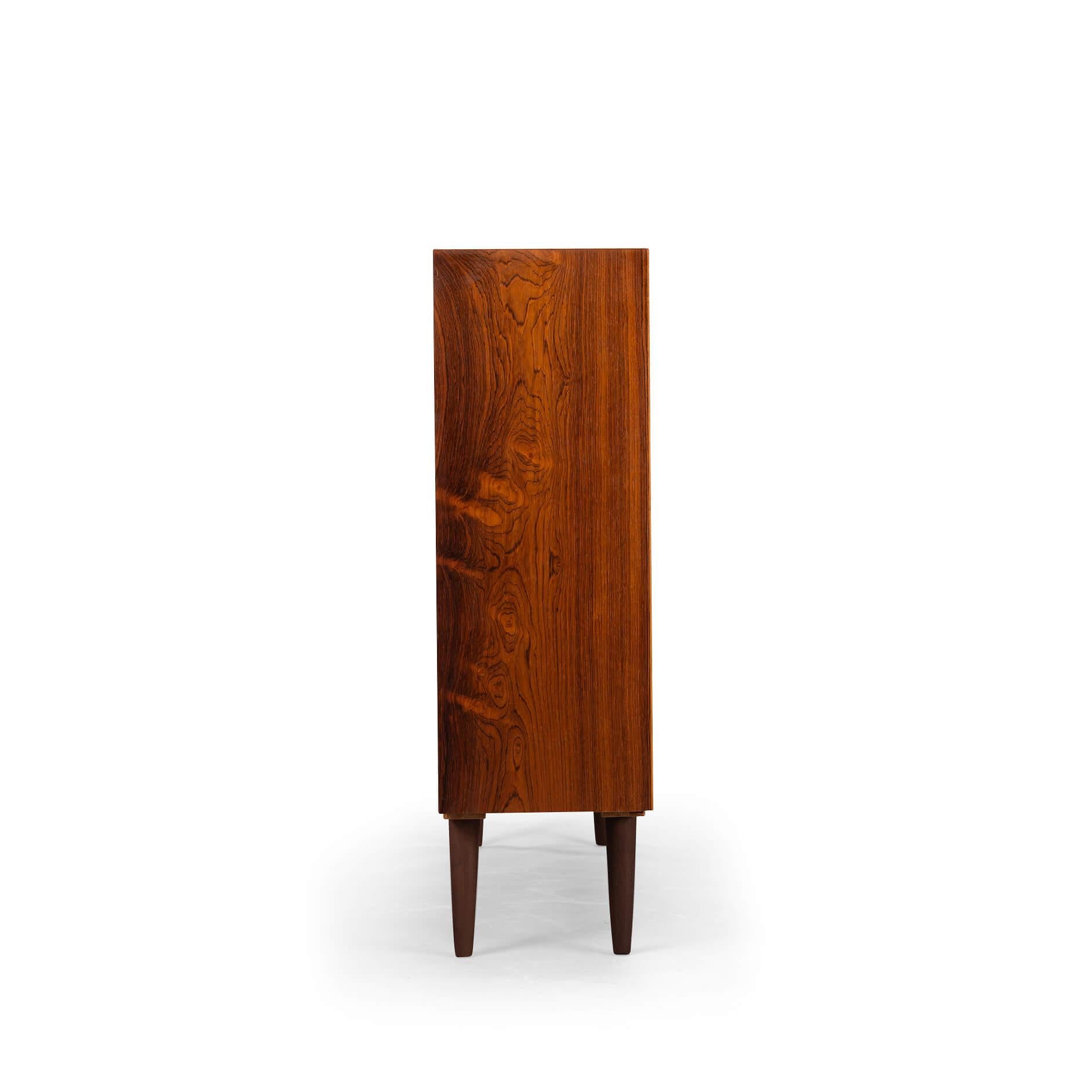 Danish tall bookcase in beautiful rosewood veneer. Designed by Carlo Jensen and made by Hundevad & Co.

This bookcase is in very good vintage condition and has a total of 4 height-adjustable shelves.
