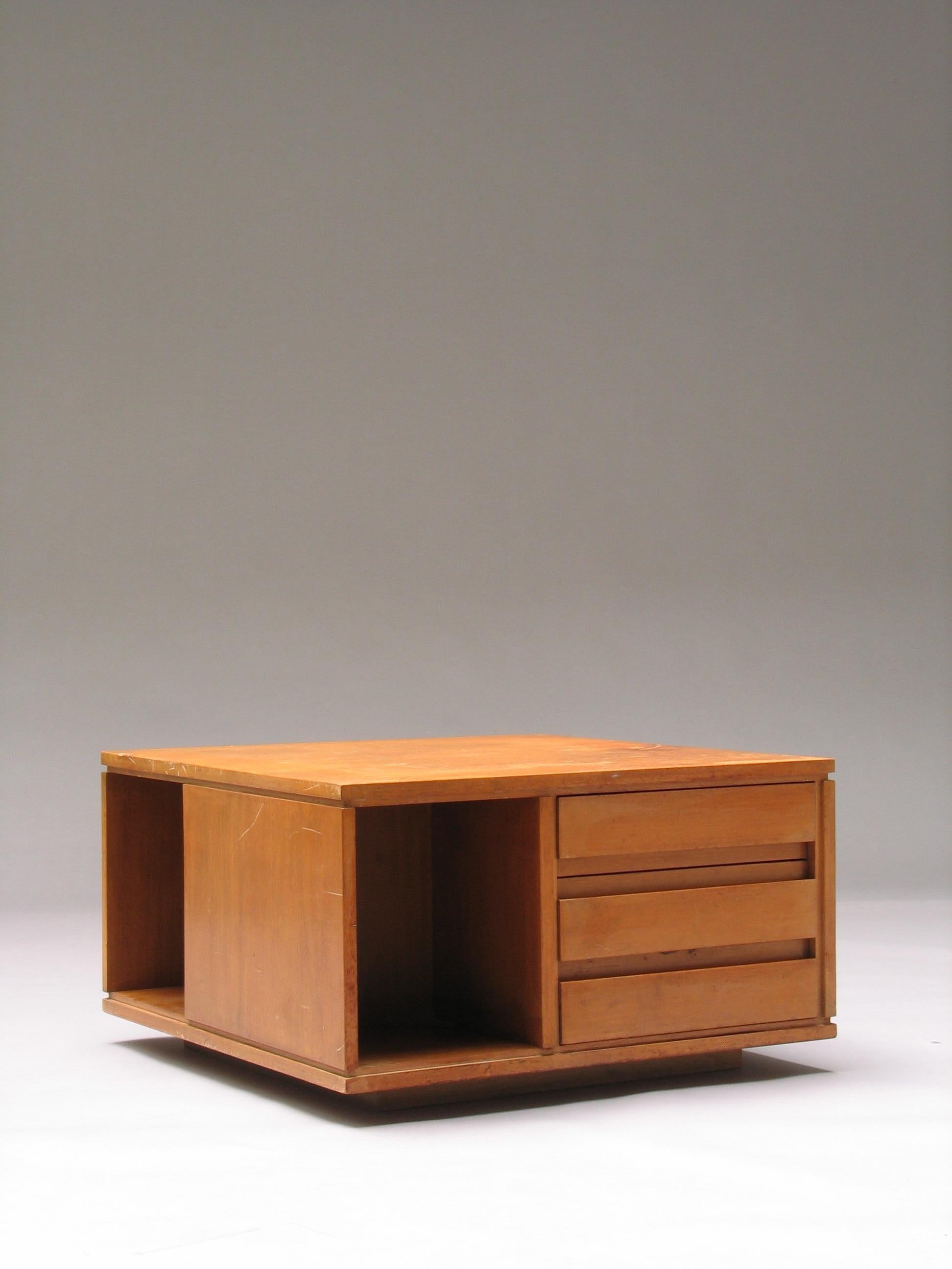 Diseñada por Ico Parisi y fabricada por Fratelli Rizzi en Cantù hacia 1957, esta singular mesa baja cuadrada es única en su especie. Tiene tres cajones enrasados en un lado, dos compartimentos abiertos en otros dos lados y una superficie cerrada en