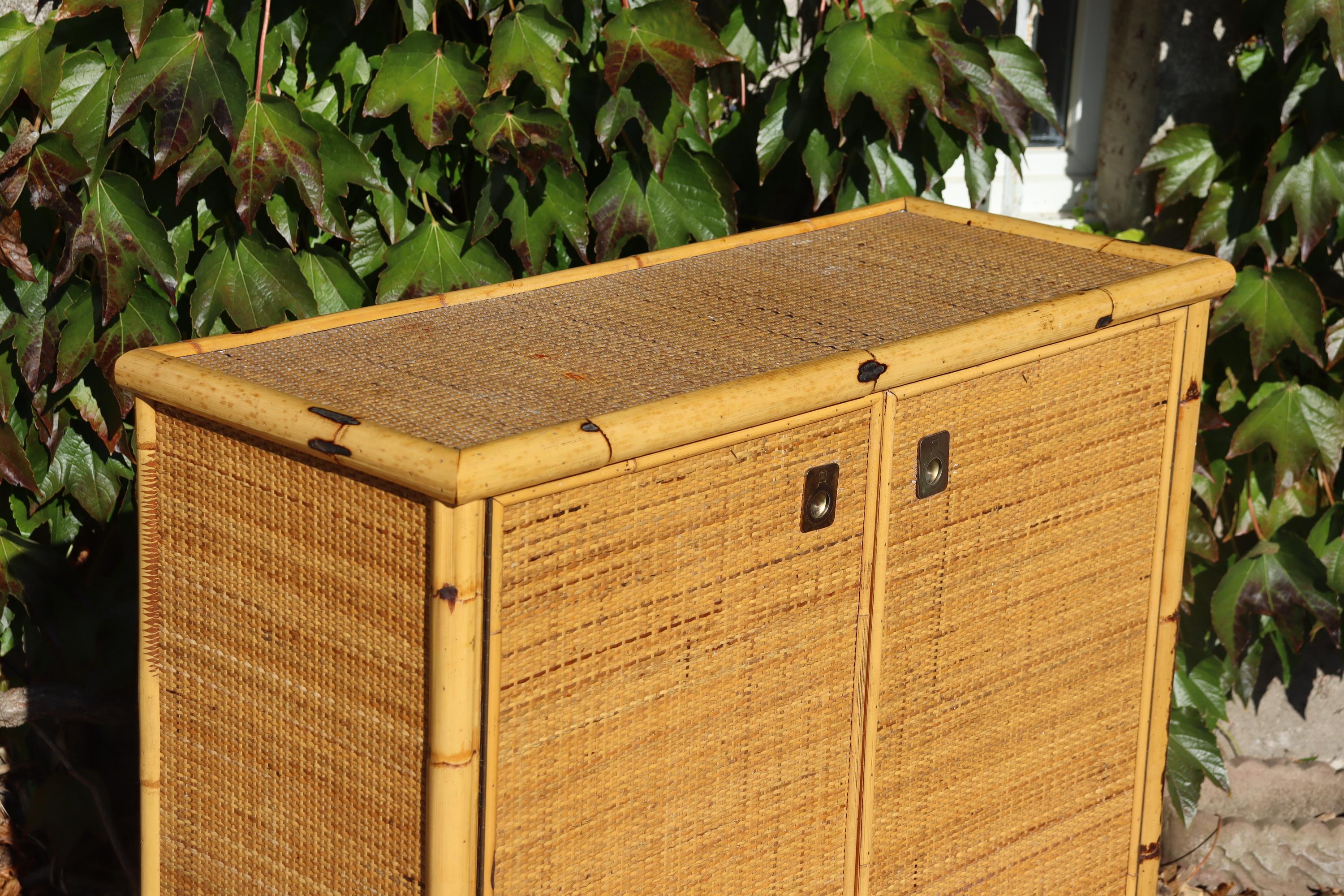 Low sideboard in rattan and bamboo from the 1960s, signed on the inside of the door, gilded brass handles in very good condition