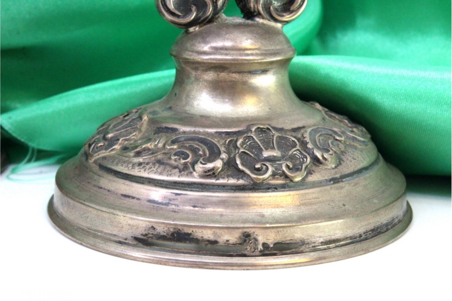 Description: Low silver candelabra with two lights, circular bases with shell-shaped reliefs. Metal: Silver. Origin: Portuguese. Mark: standing eagle. Weight: 305.69 grams. Dimensions: 19cmx16.5cm. Content: 833/1000. Assay Mark: Yes, between 1938