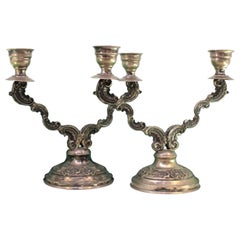 Low silver candelabra with two lights and shell-relief circular bases Low silver candelabra with two lights and shell-relief circular bases