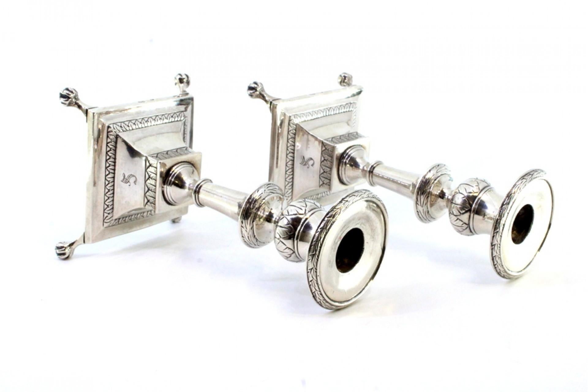 Silver Low silver candlesticks with engraved shafts and four claw-shaped feet For Sale