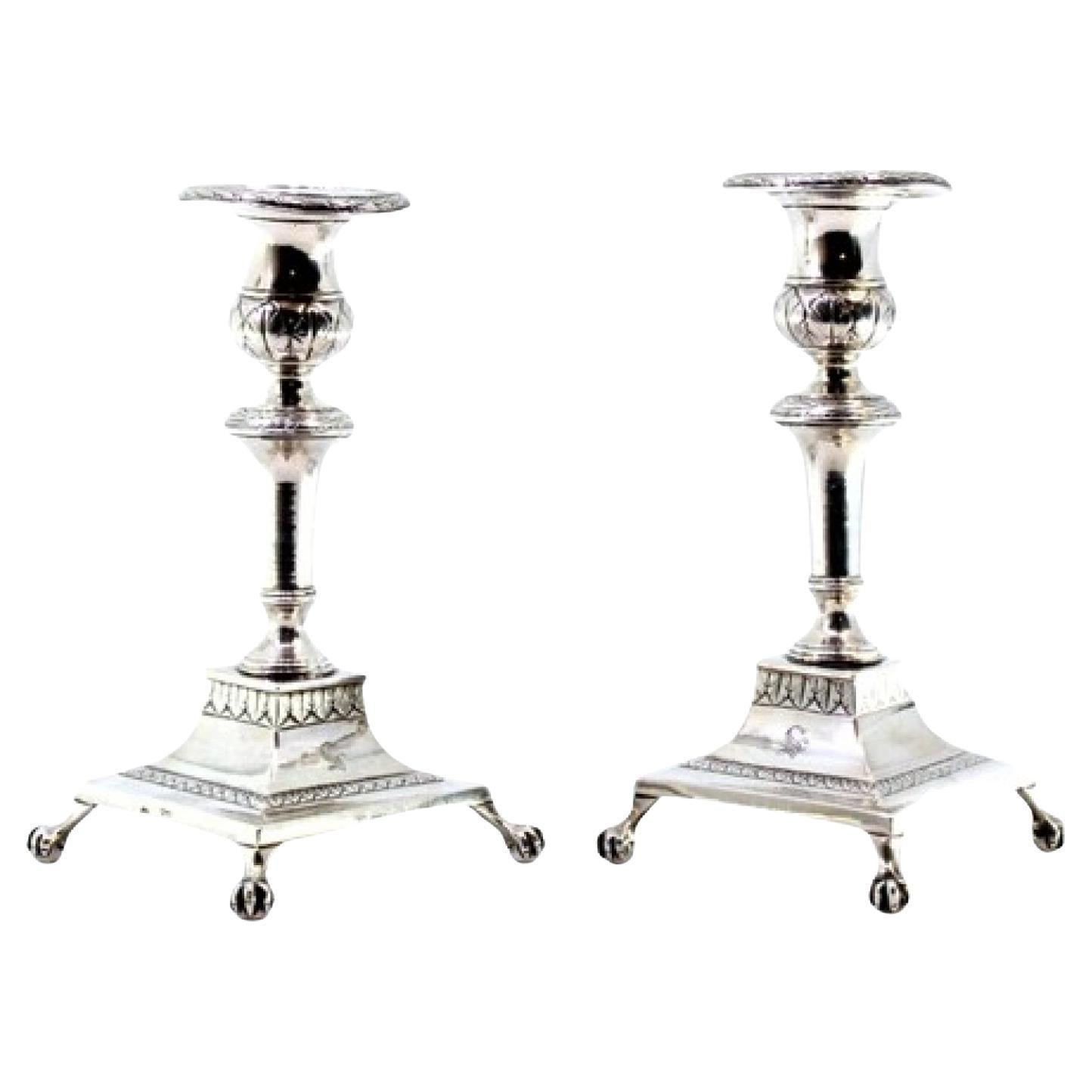 Low silver candlesticks with engraved shafts and four claw-shaped feet