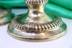 Low silver candlesticks with fluted reliefs on circular beaded bases
