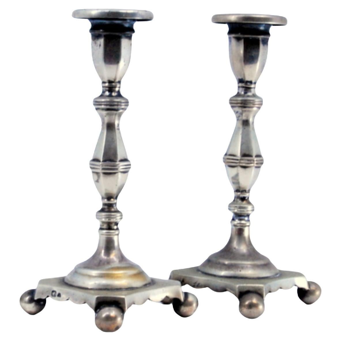 Low silver candlesticks with fluted reliefs on circular beaded bases