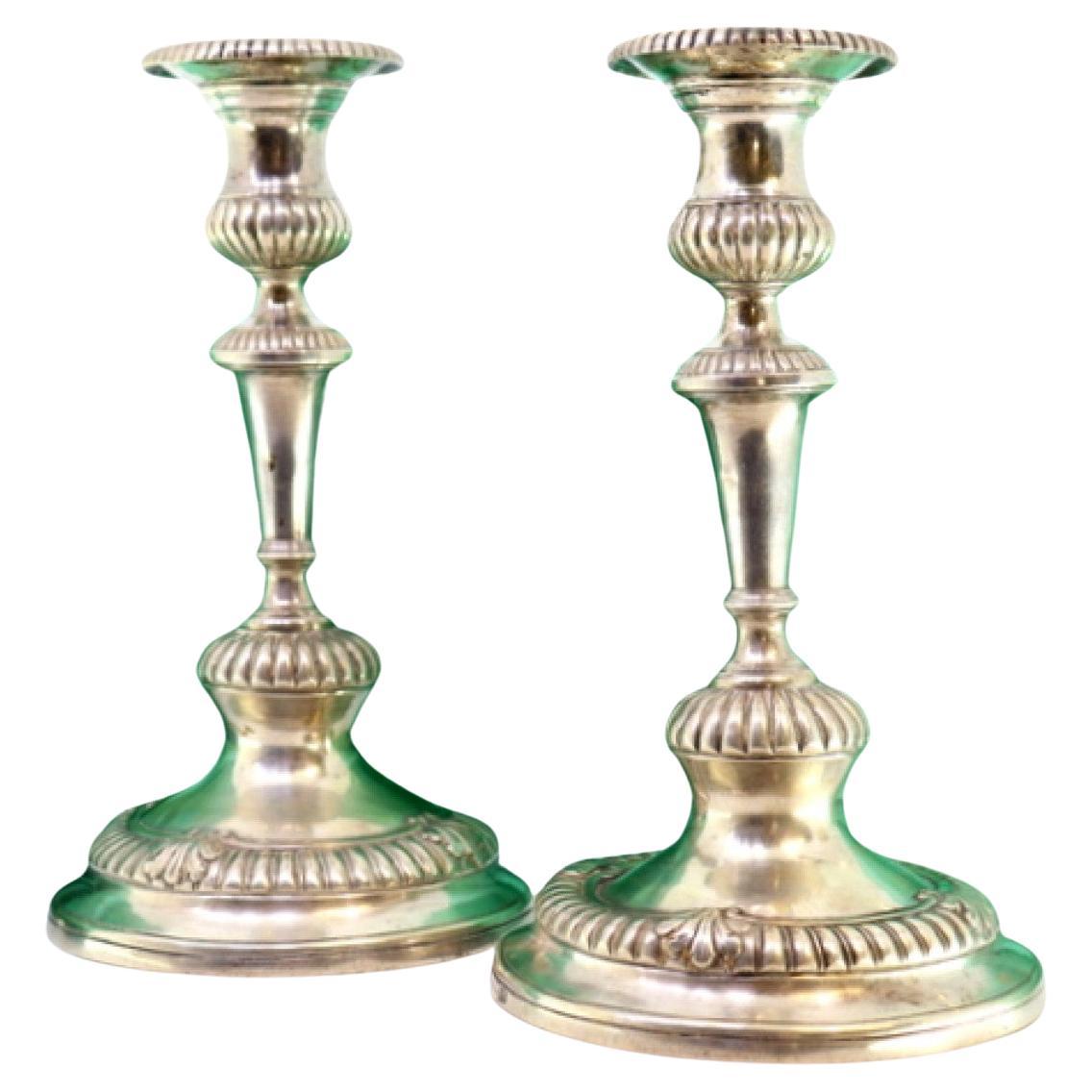 Low silver candlesticks with fluted reliefs on circular beaded bases