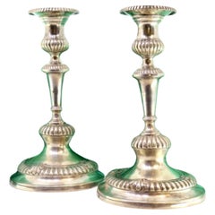 Low silver candlesticks with fluted reliefs on circular beaded bases