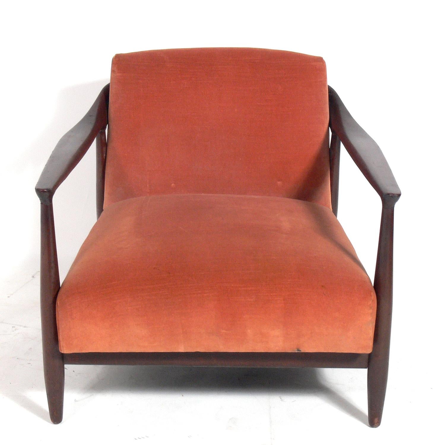 Low slung Danish modern lounge chair by Ib Kofod-Larsen, Denmark, circa 1960s. This chair is currently being refinished and reupholstered. The price noted below includes refinishing and reupholstery in your fabric. Simply send us your fabric after