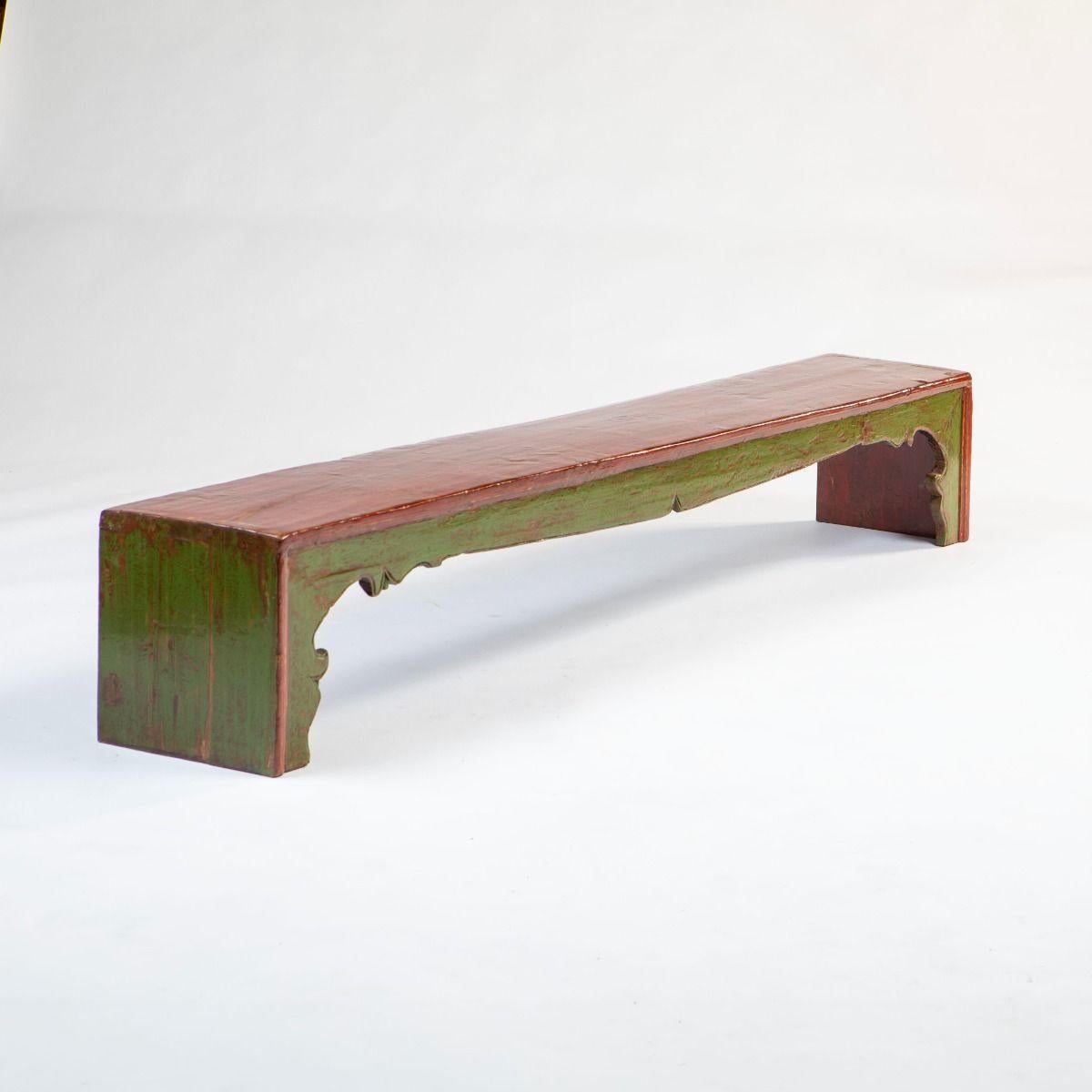 Elegante Kang Bank / Tisch aus Ulmenholz.
Roter Lack auf der Oberseite und den Kanten.
Detaillierte Schürze und Seiten mit grüner Lackierung.

Qing-Zeit 1860-80
Aus der Provinz Gansu